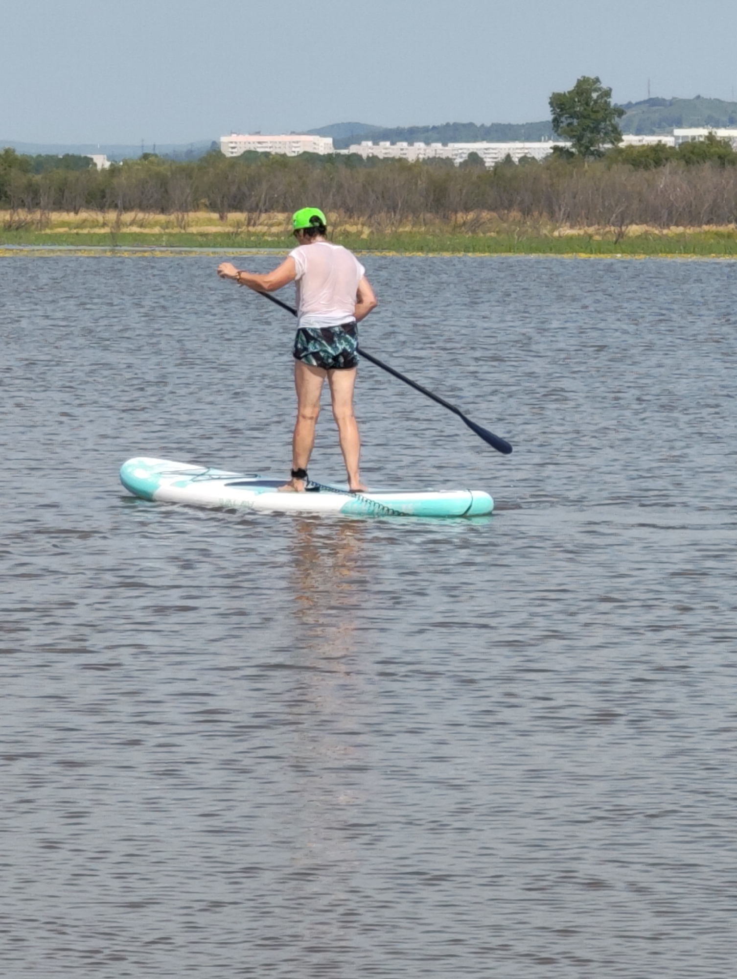 Paddleboarding on calm water, standing and kneeling