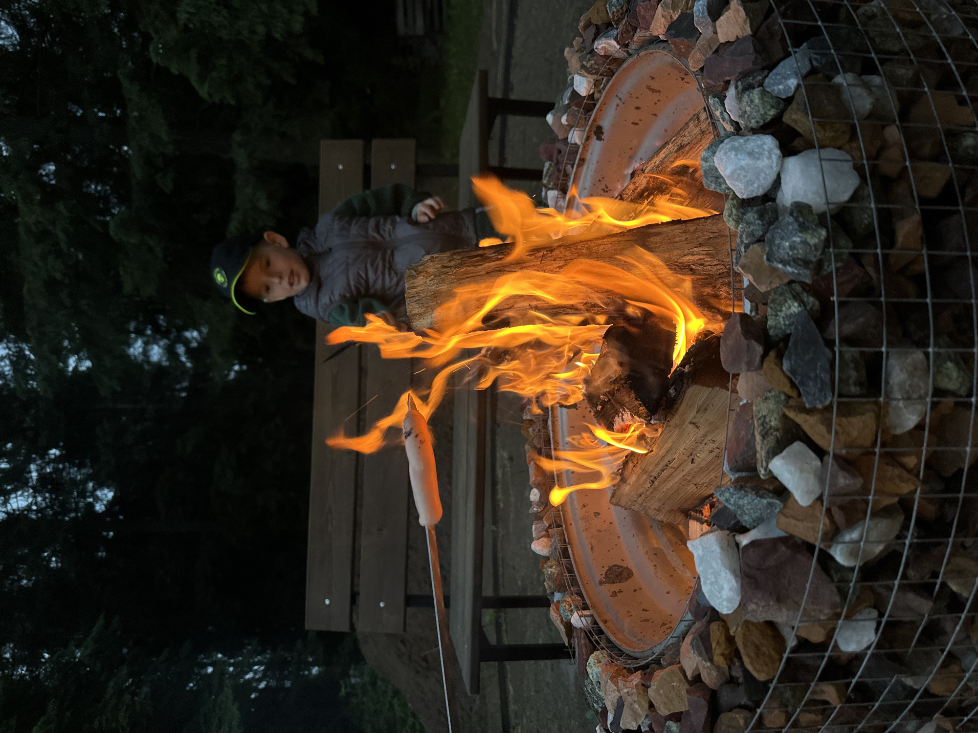 Boy tends fire pit during outdoor cooking in Russia