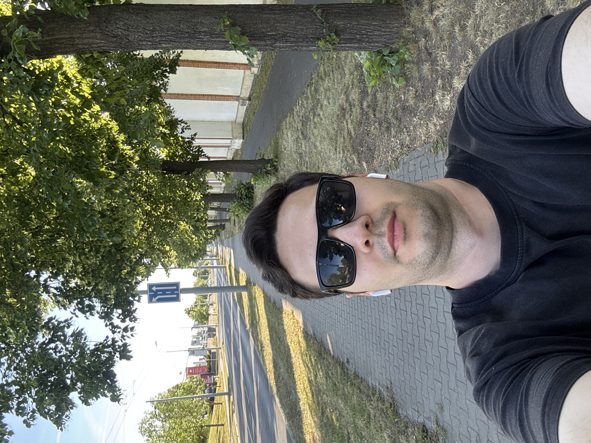 Man takes selfie on tree-lined Pilsen sidewalk