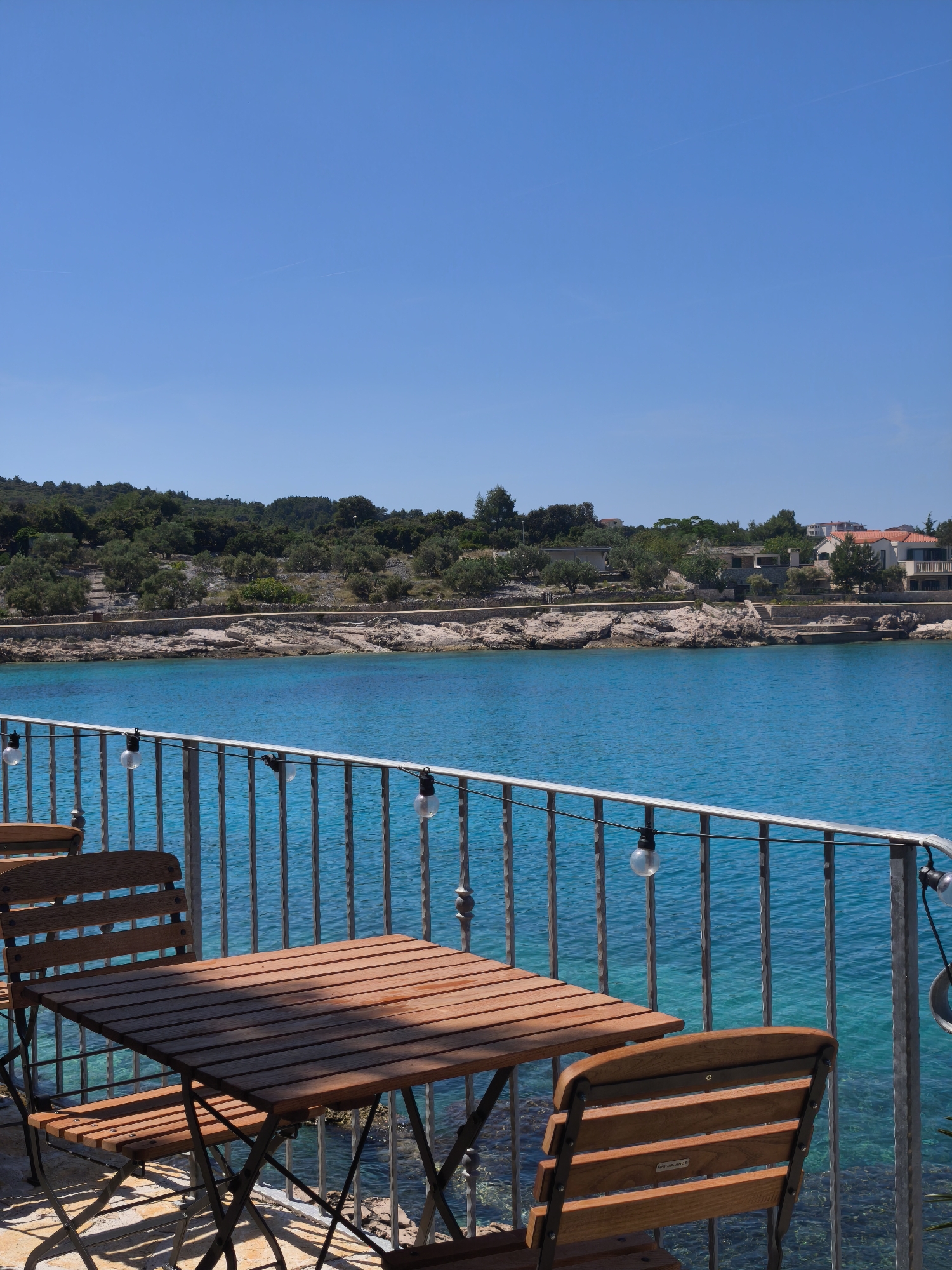 Coastal cove with turquoise waters and hillside dining captured
