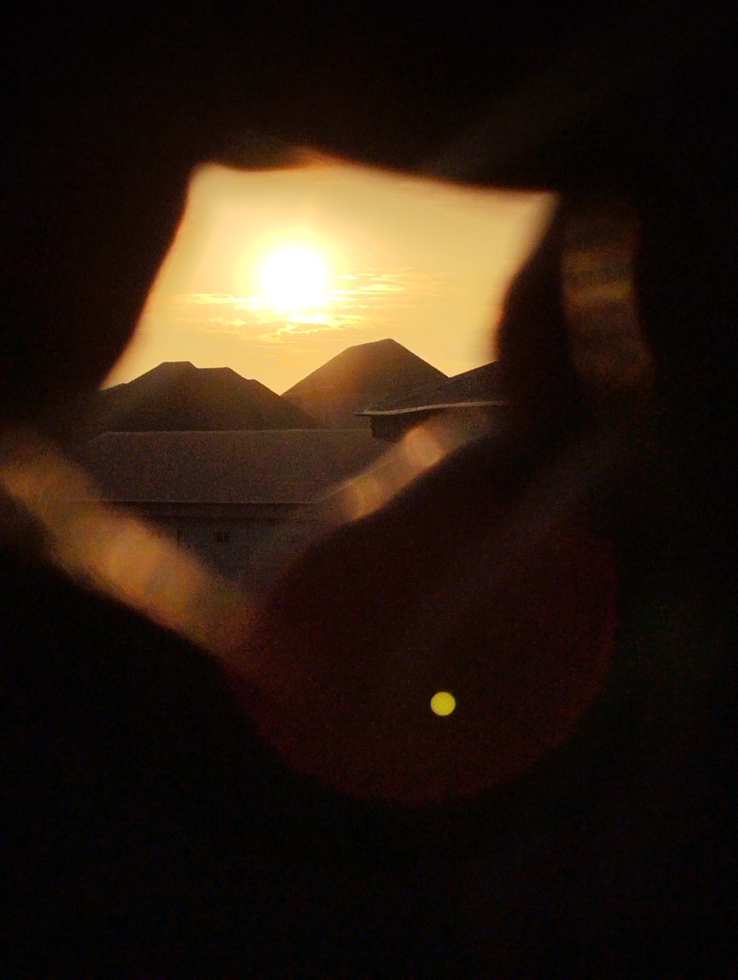 Sunset captured through hand frames in Fegge, Nigeria