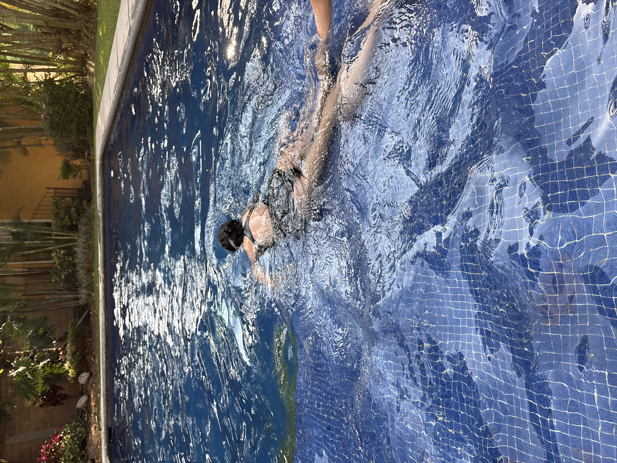 Woman swims in blue-tiled pool in Cuernavaca, Mexico