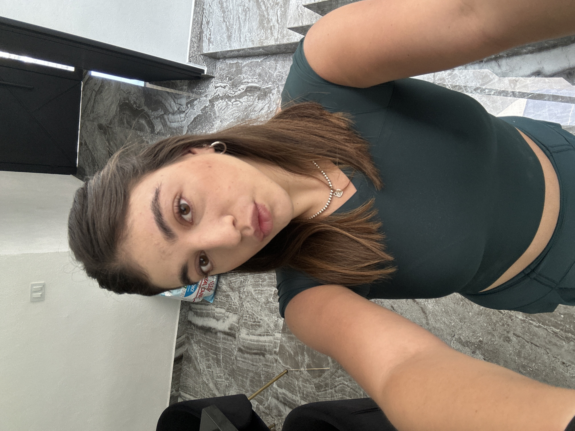 Woman takes selfies in green workout clothes in Puebla