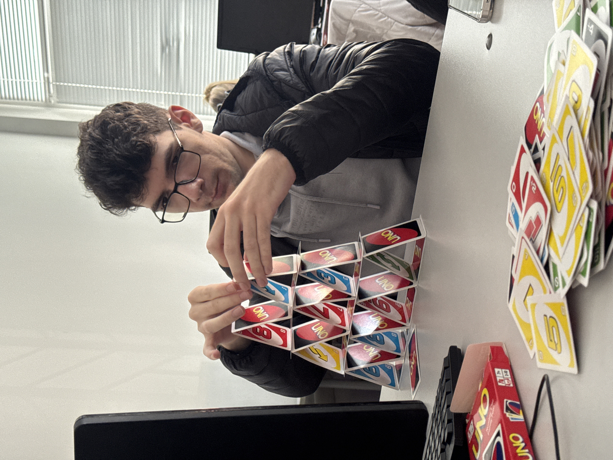 Man builds Uno card house in Bulgarian office setting