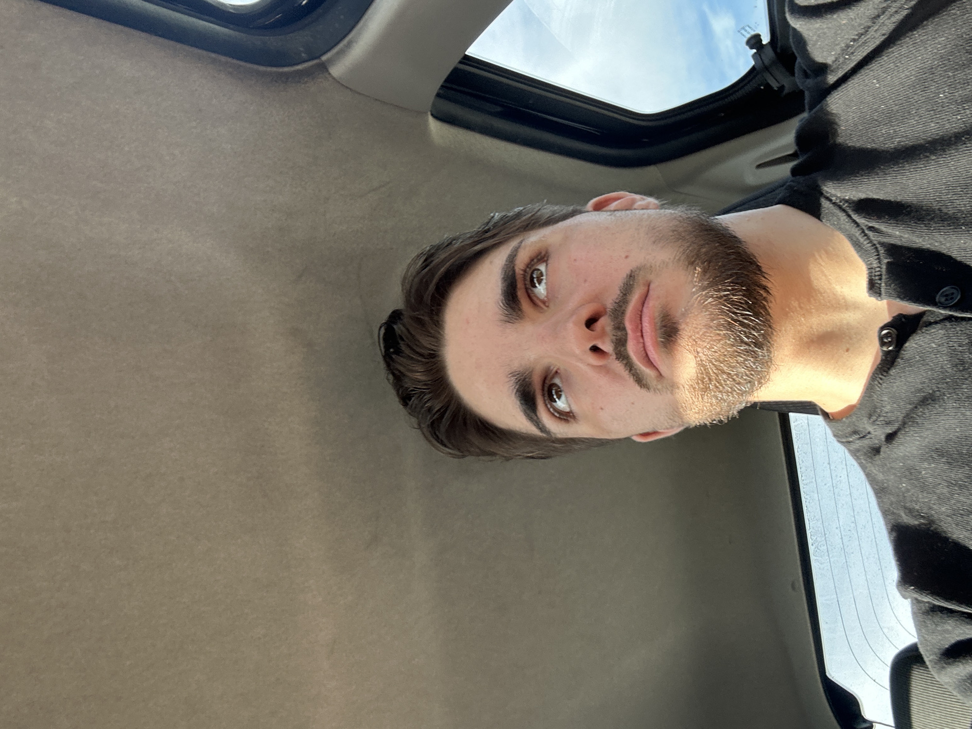 Man gazes skyward through car sunroof in Switzerland