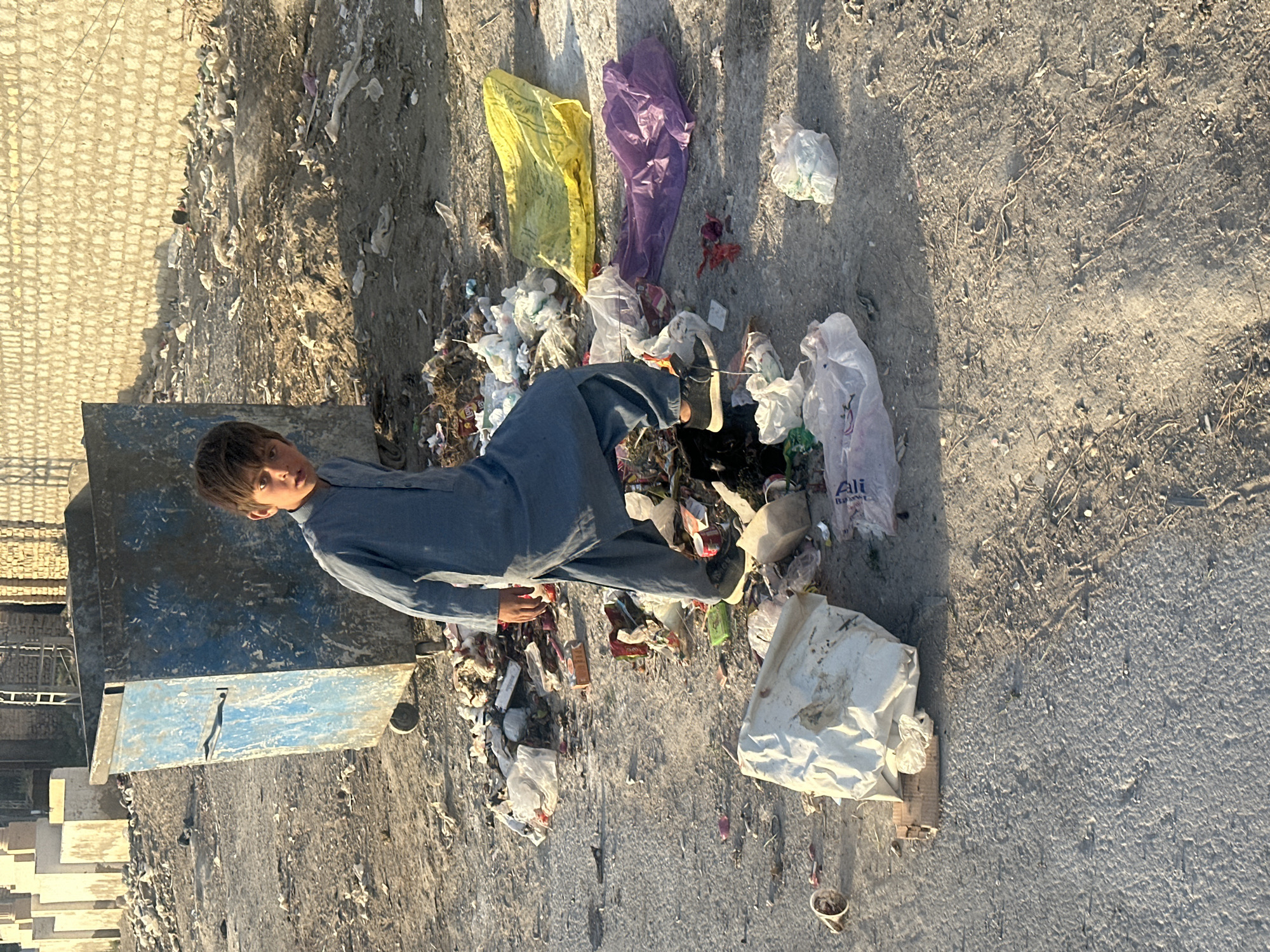 Boy stands amid litter in Quetta City Tehsil