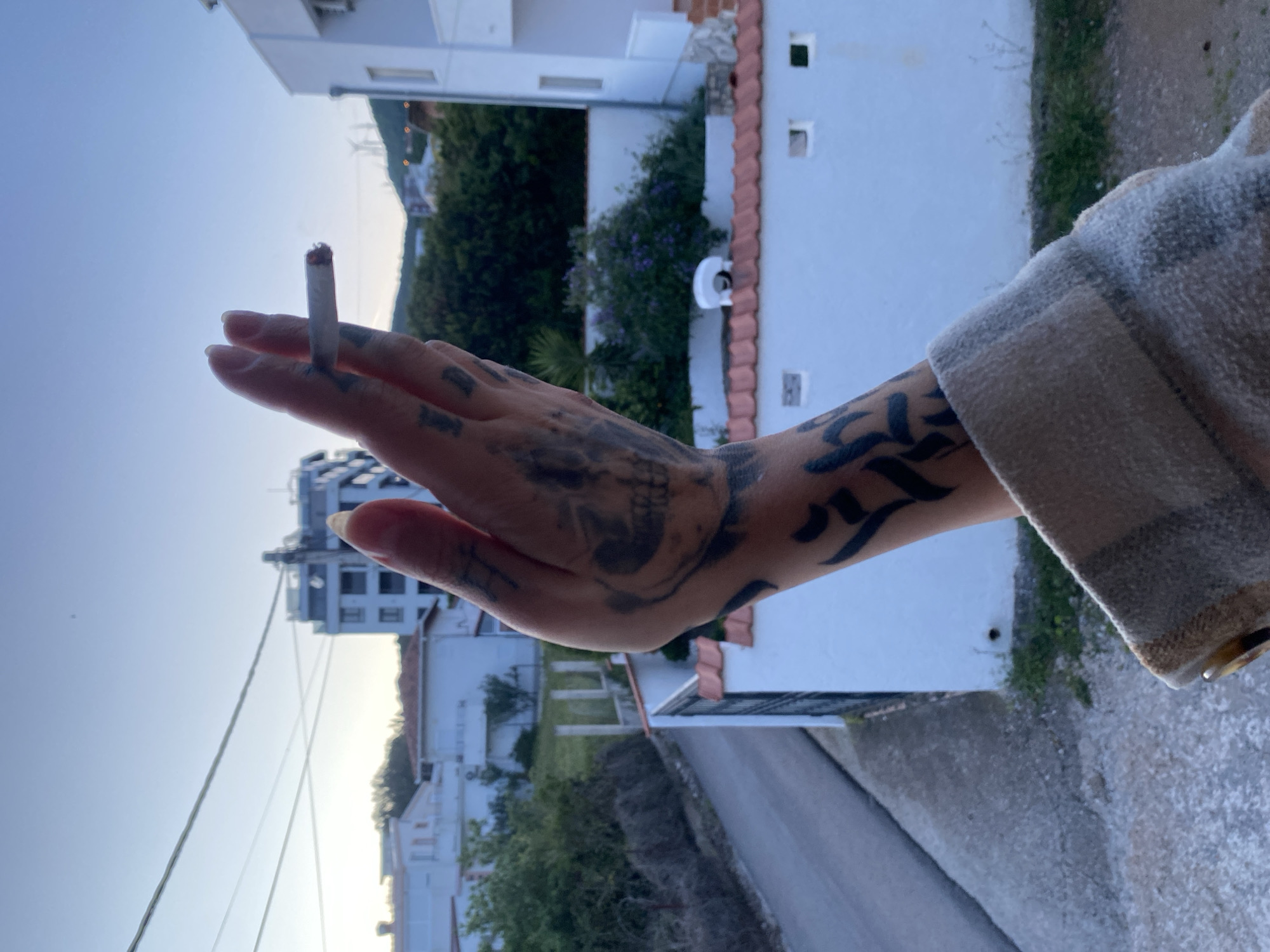 Tattooed person smoking cigarette observed in Kunje, Montenegro