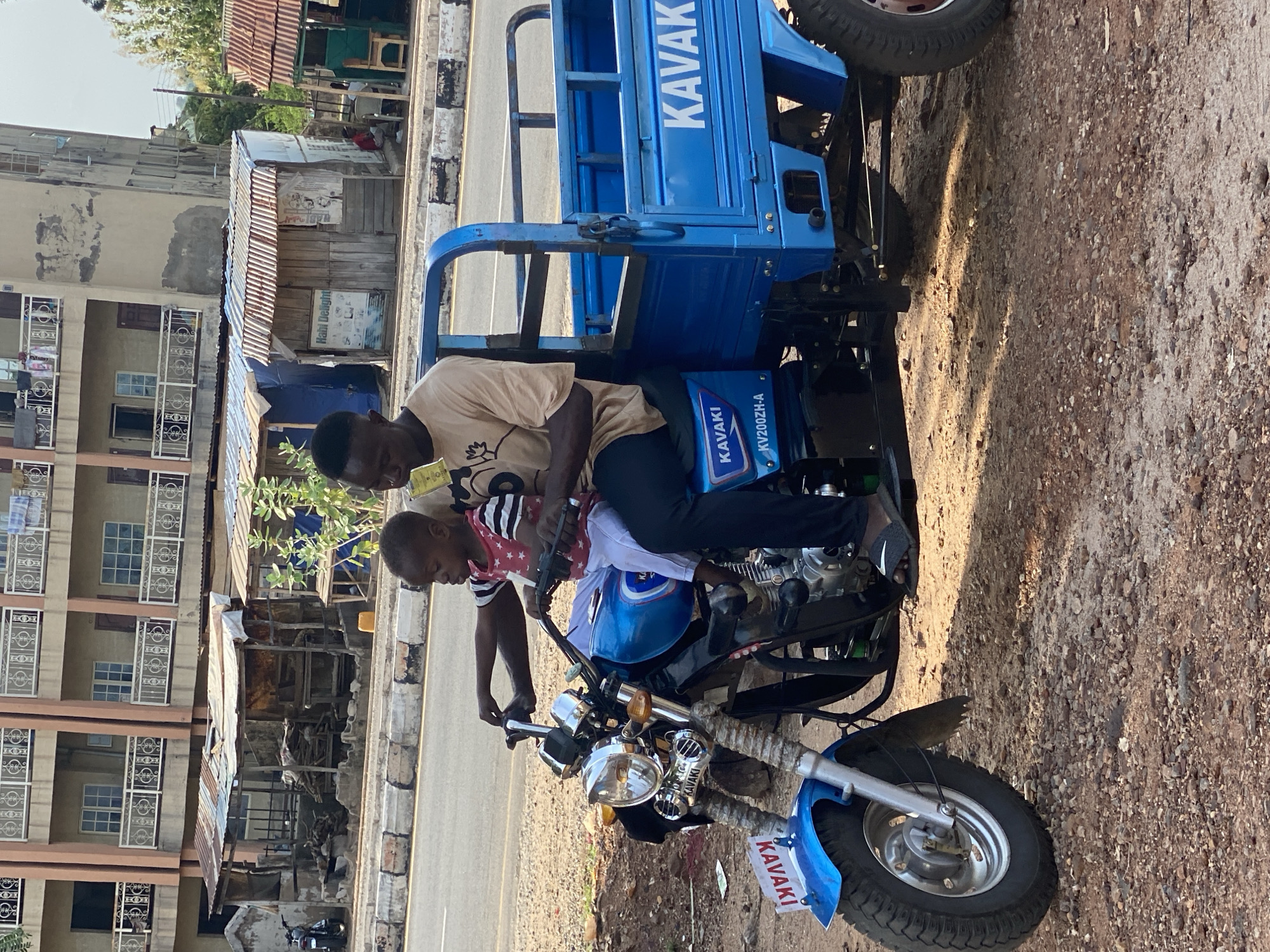 Man, child share motorcycle ride in Nigerian town