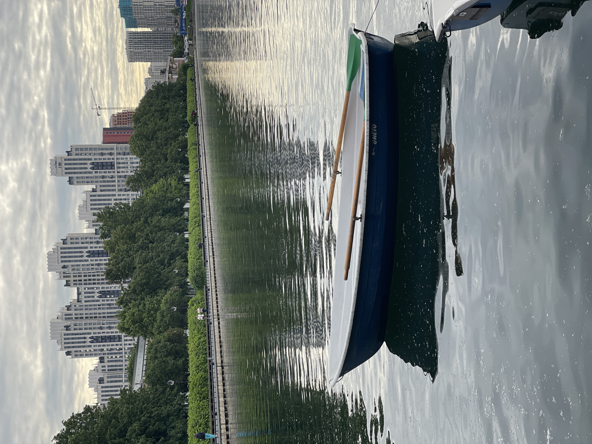 Urban waterfront with boat rentals, trams, and pedestrians documented