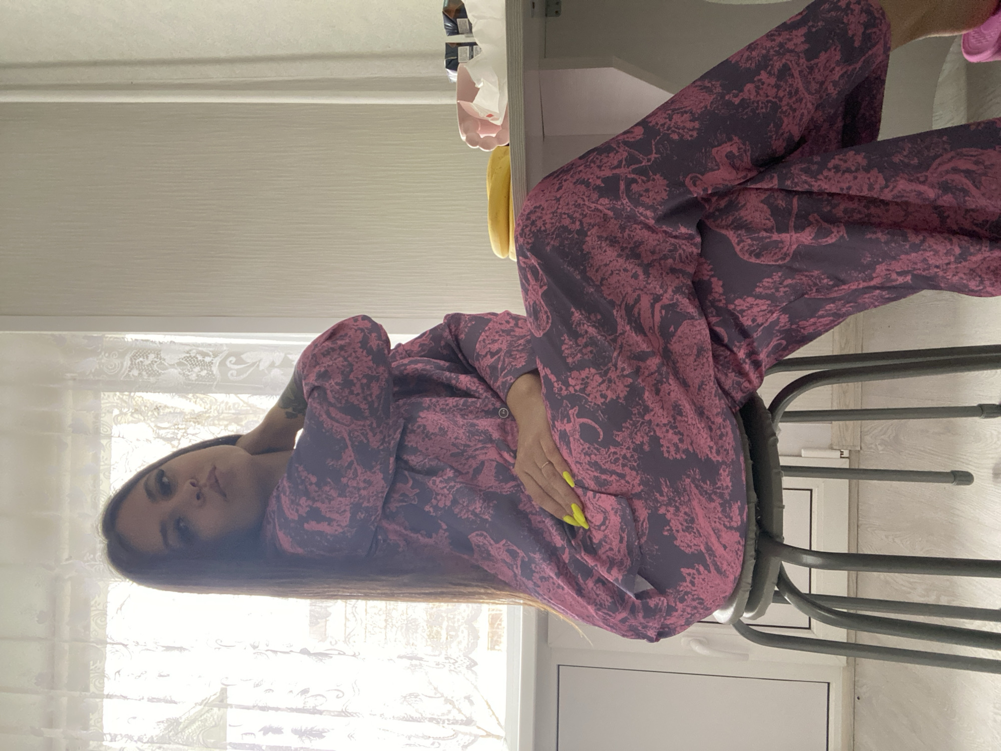 Woman in purple pajamas sits indoors in Chaikovsky, Russia