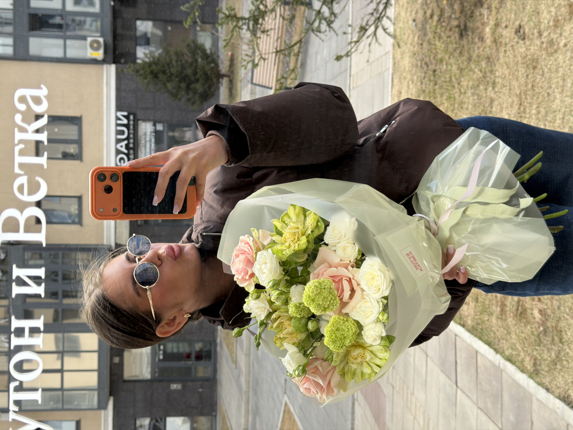 Woman takes selfie with flowers at Krasnoyarsk market
