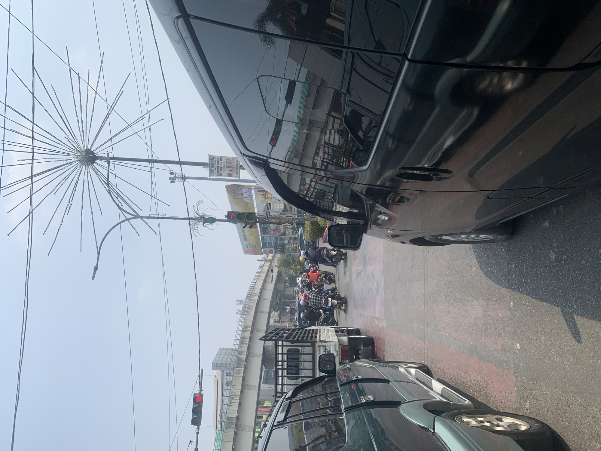 Morning traffic flows through a busy Palembang street corridor