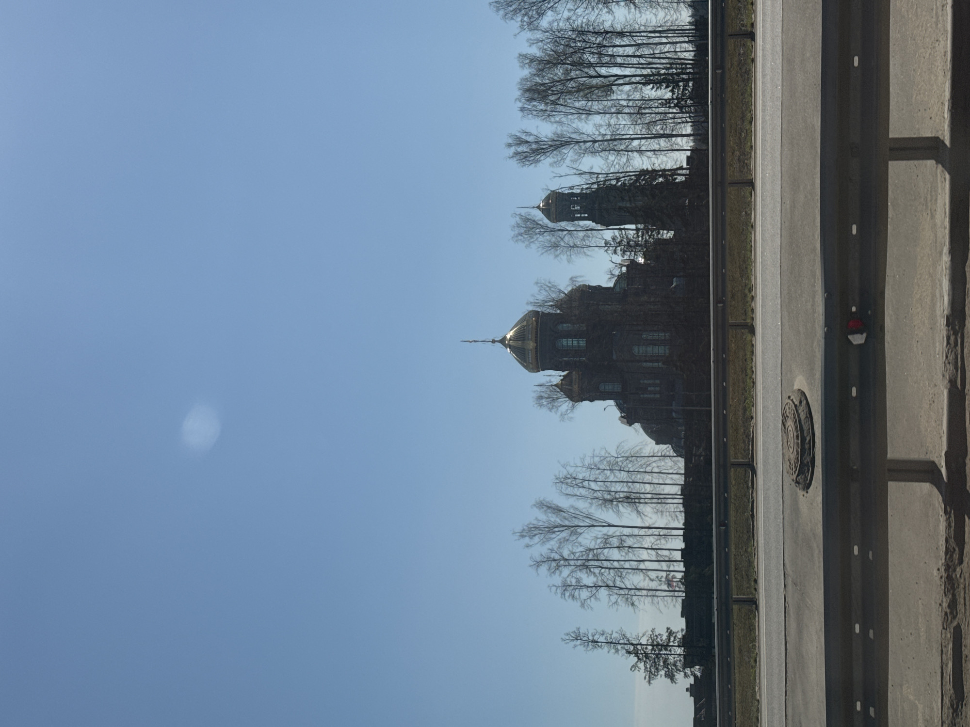 Golden-domed church with bell tower spotted among bare trees