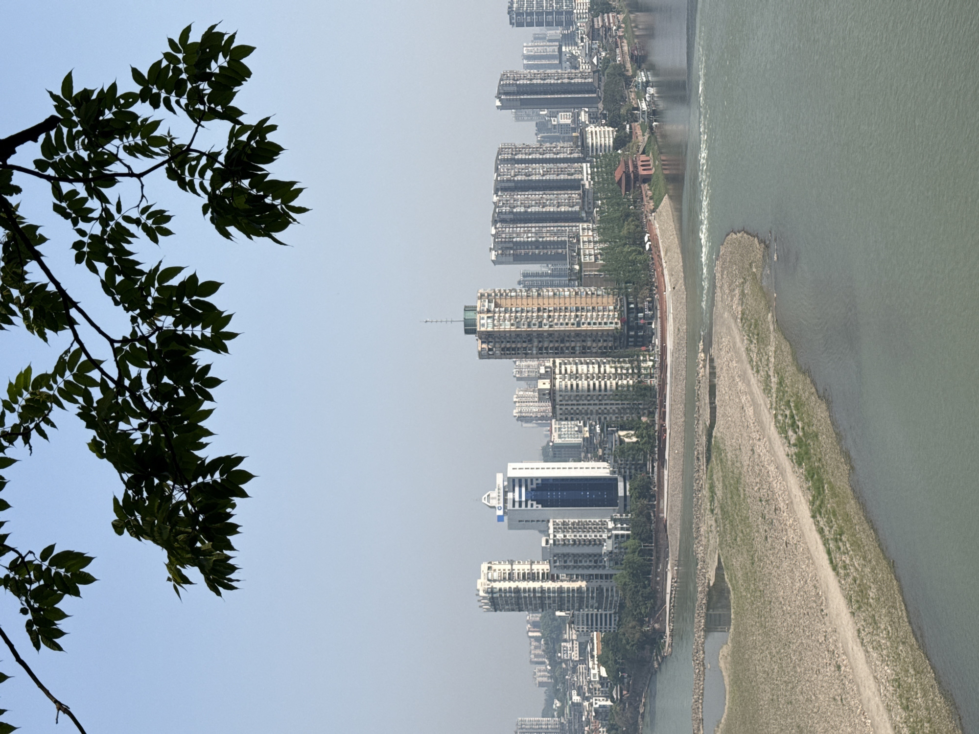 Panoramic riverside cityscape observed from elevated viewpoint in Shizhong