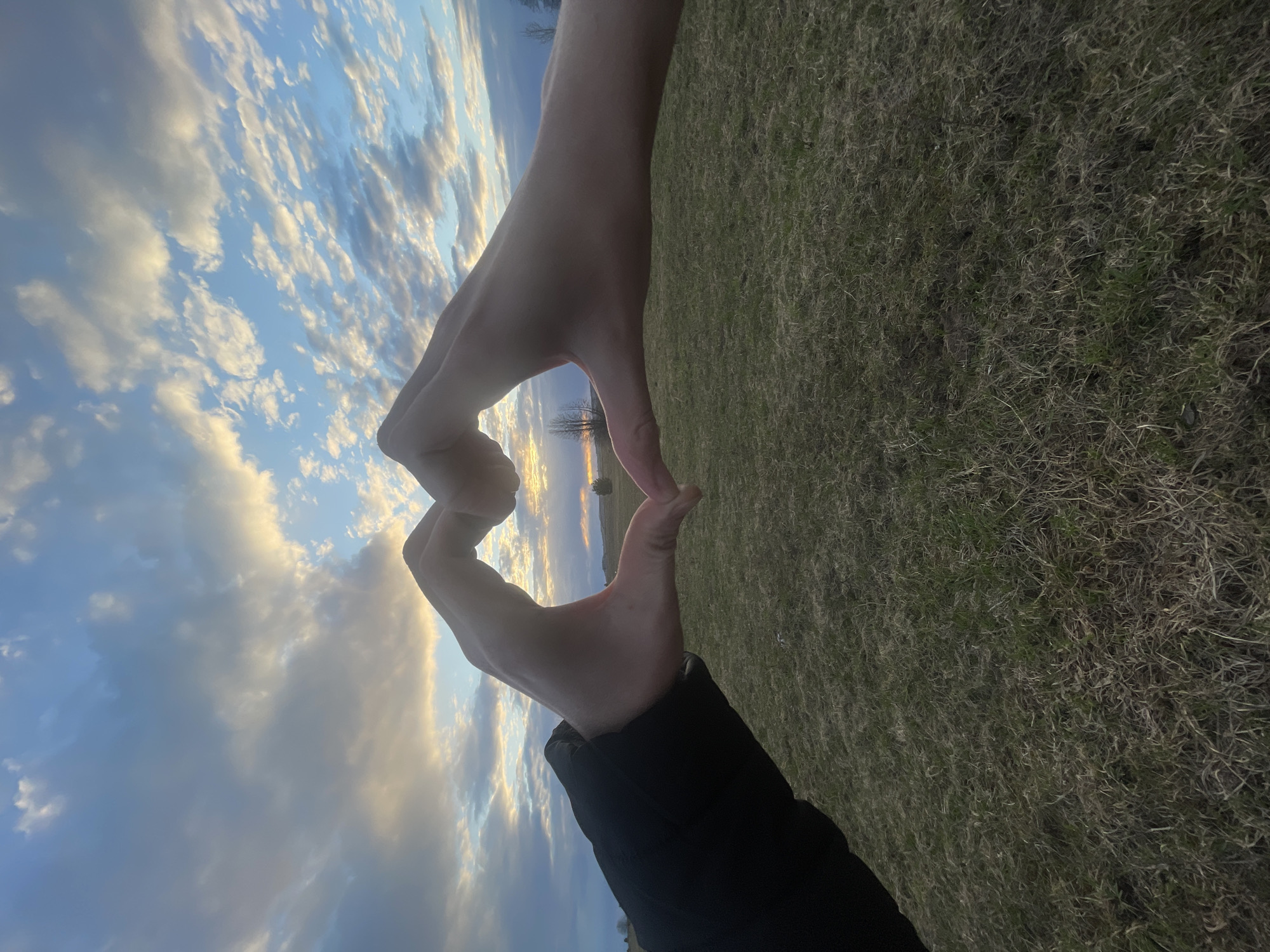 Heart gesture photographed against sky in Kuyeda, Russia