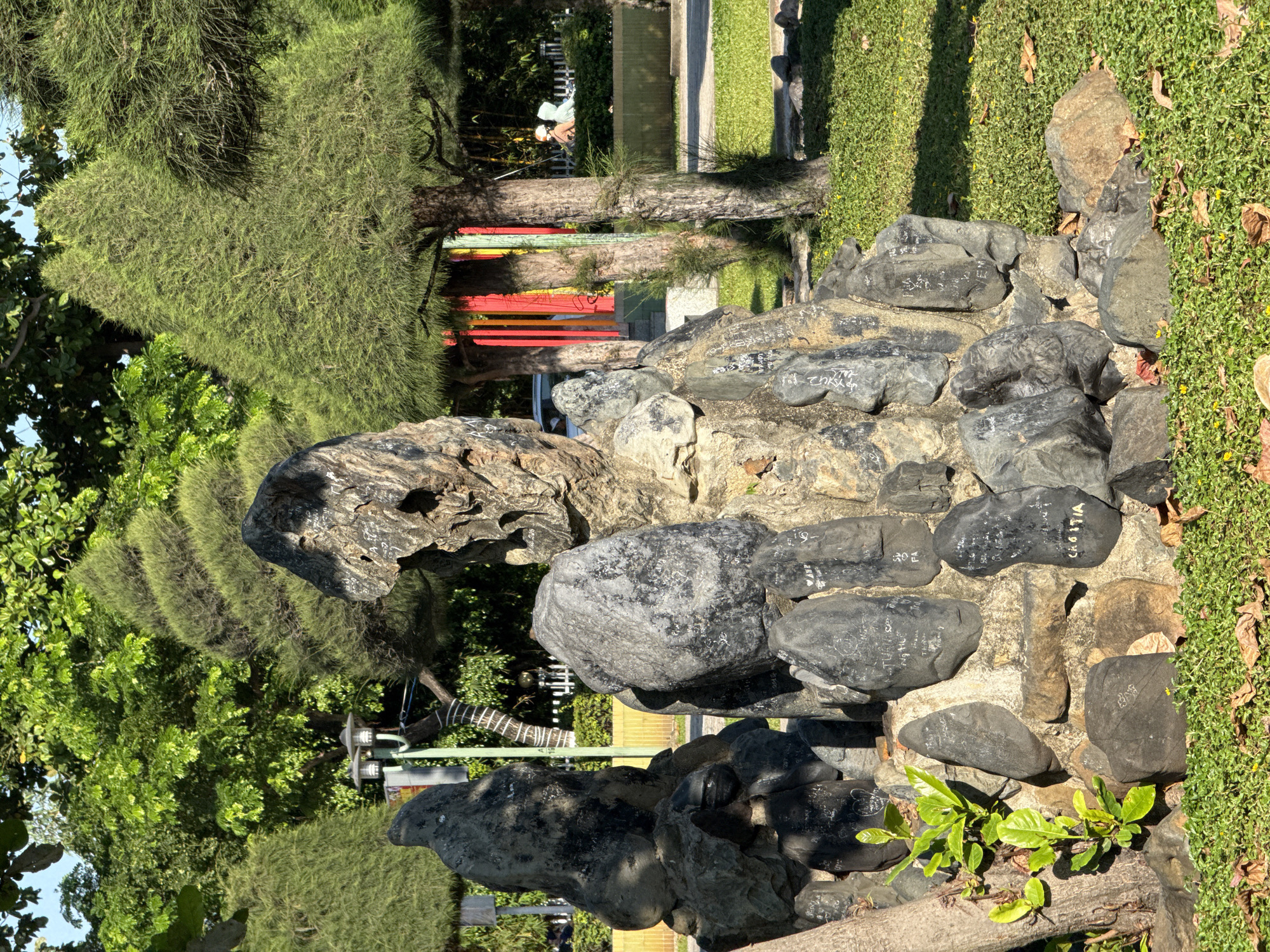 Nha Trang park grounds with rock sculptures and a groundskeeper at work