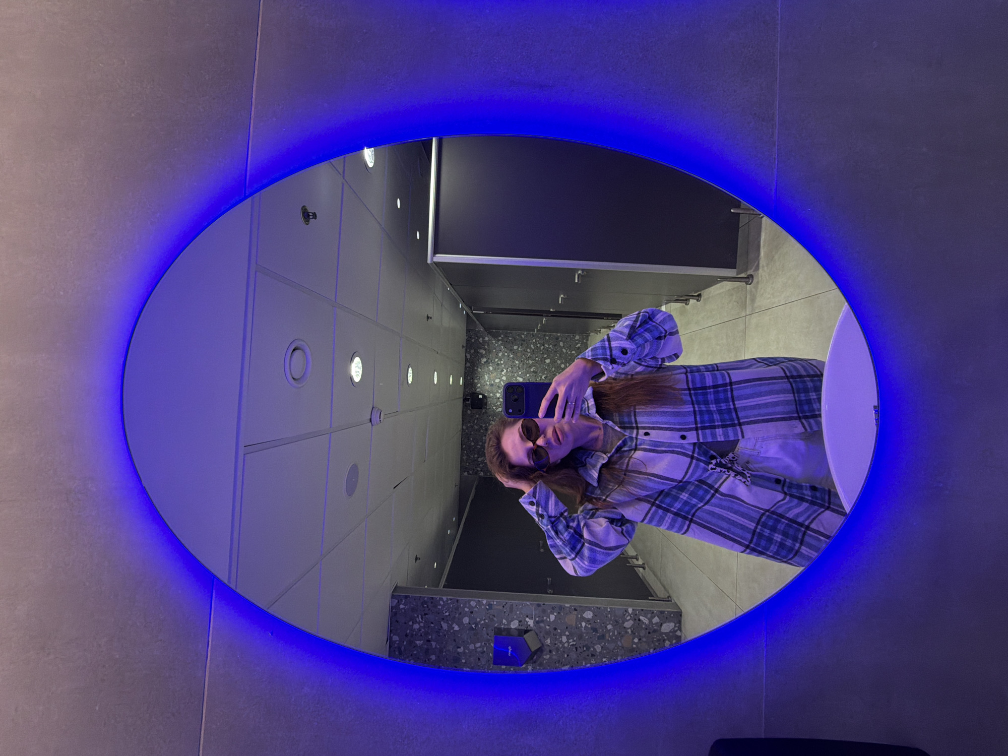 Woman takes selfie in LED-lit restroom mirror in Israel