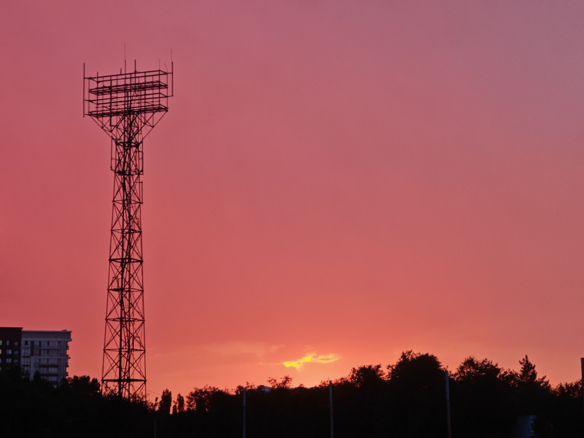 Telecom tower silhouetted against Bishkek's sunset sky