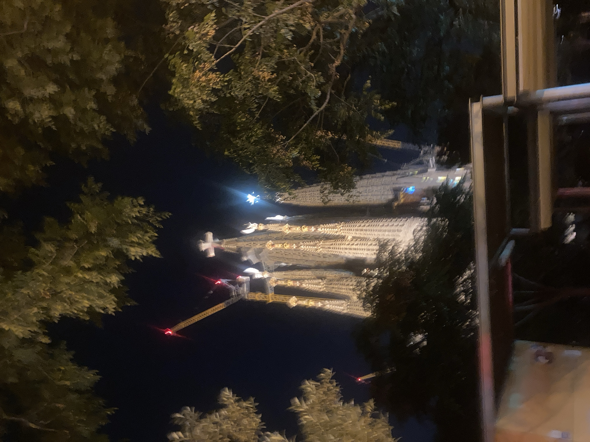 Sagrada Familia illuminated at night with construction ongoing