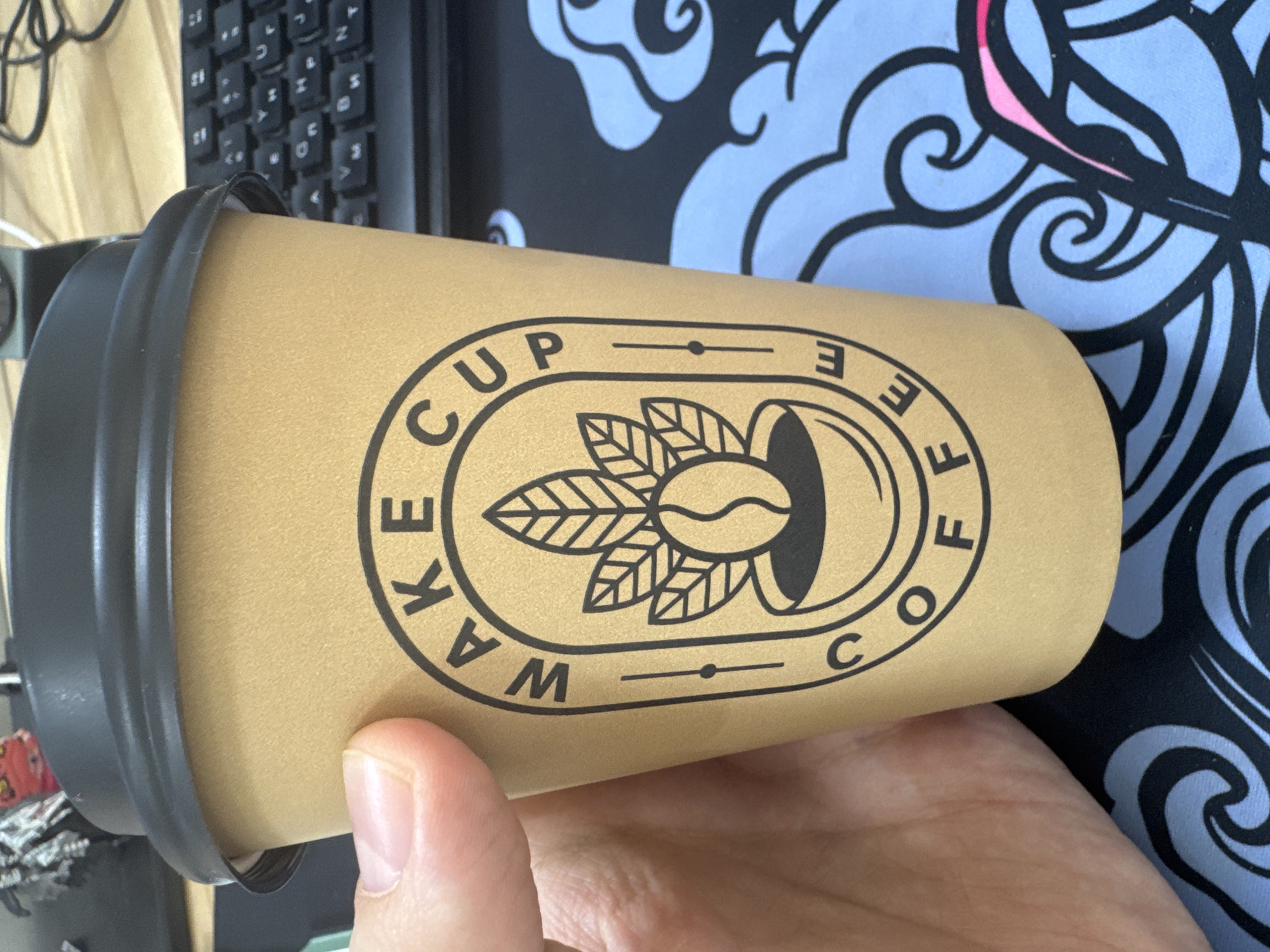 Person holds branded coffee cup at dawn
