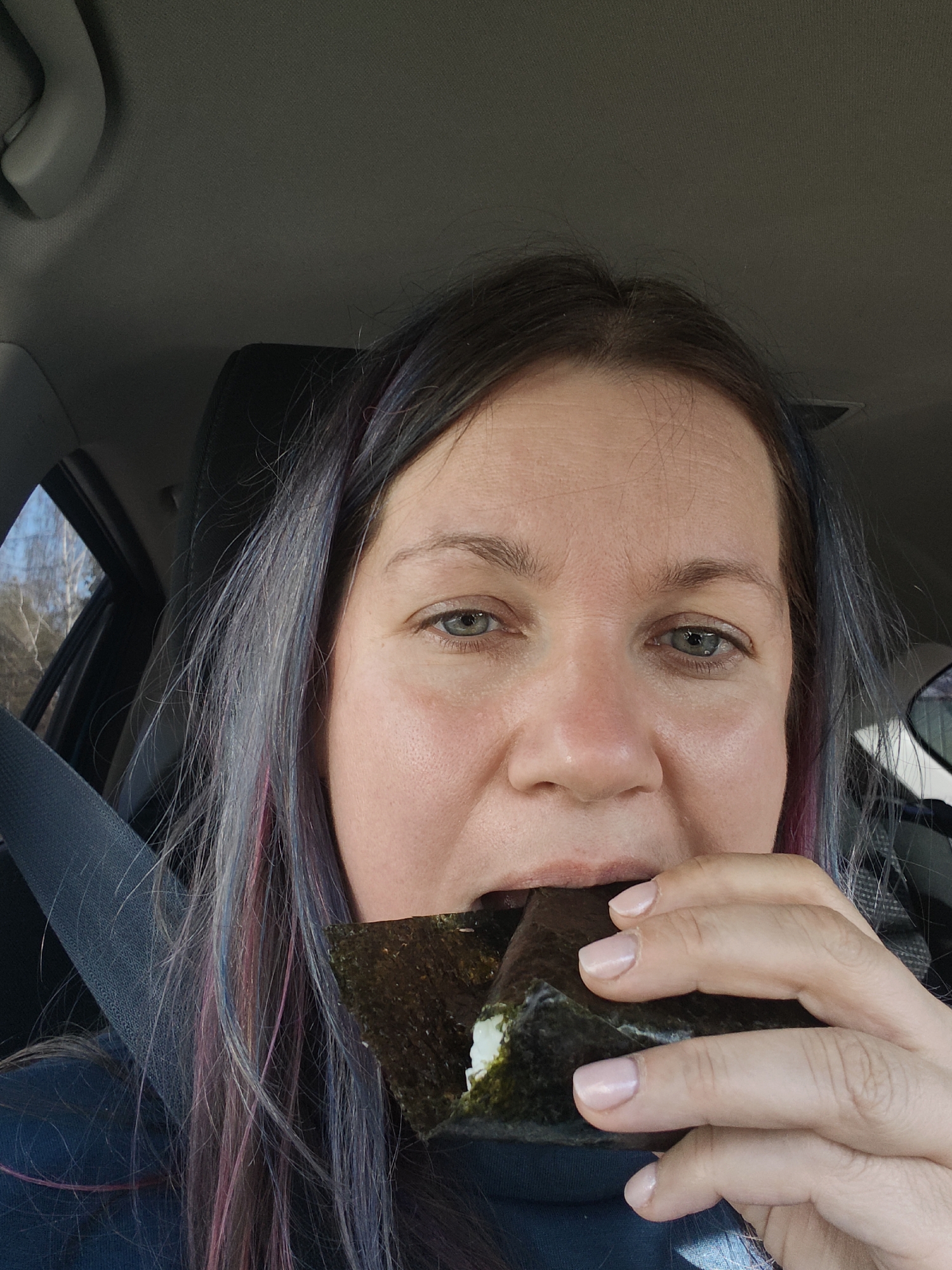 Woman photographs herself eating rice ball in car, Russia