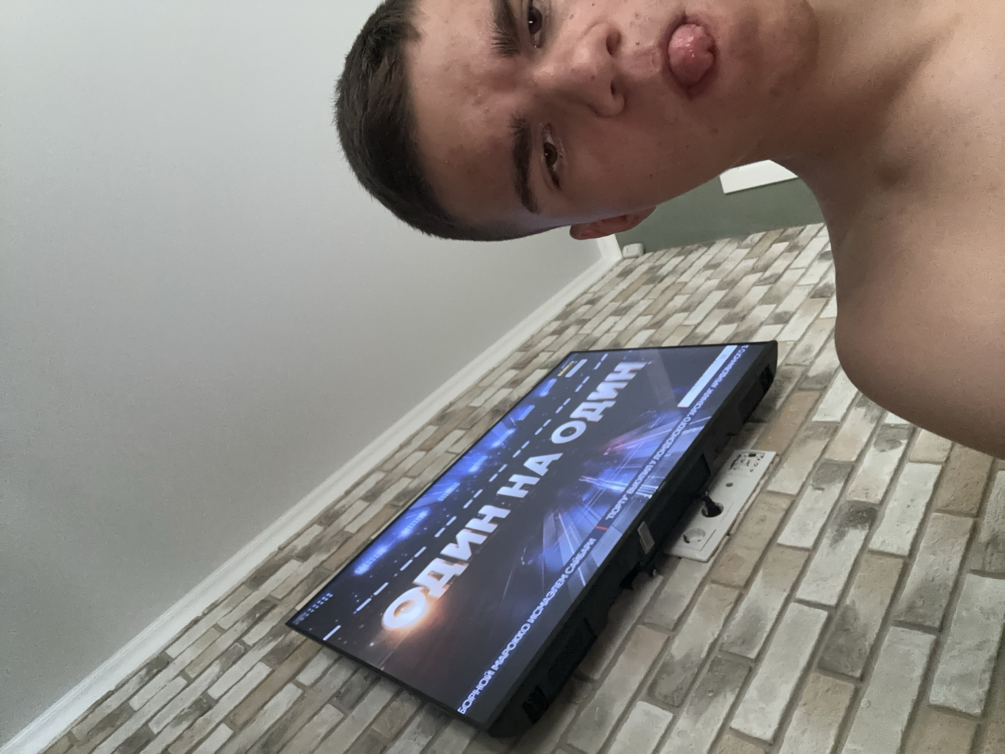 Selfie session in front of a soccer match on TV