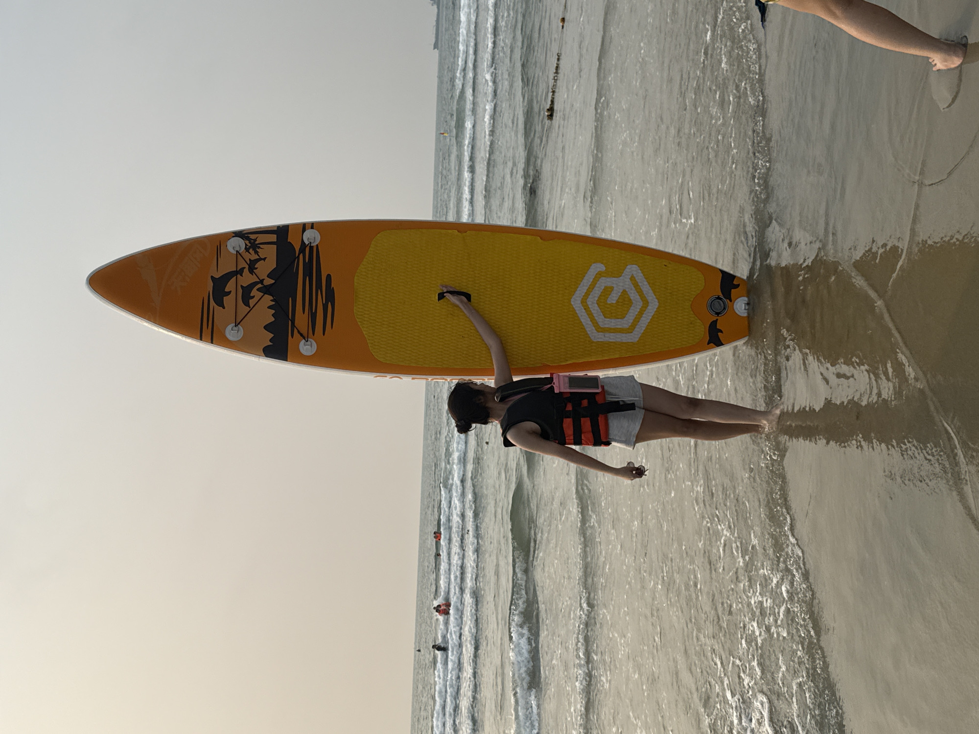 Dawn beach activities: vendors, cleaners, paddleboarder in Đà Nẵng