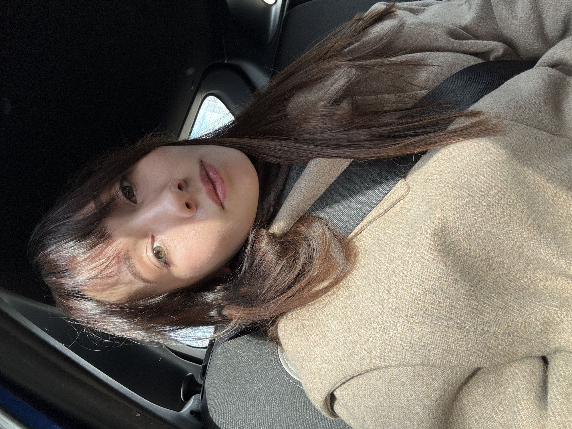 Woman in beige coat observed in car driver's seat, Kazan