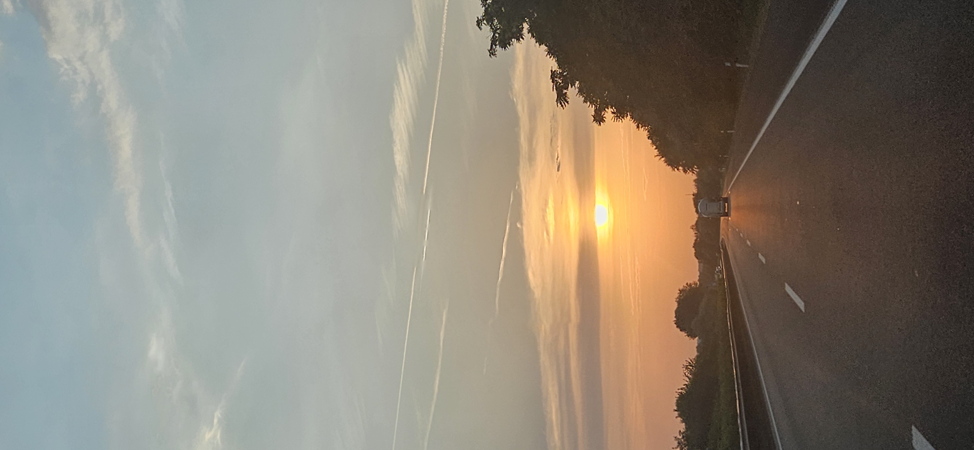 Orange sunset fades over a highway in rural Hungary