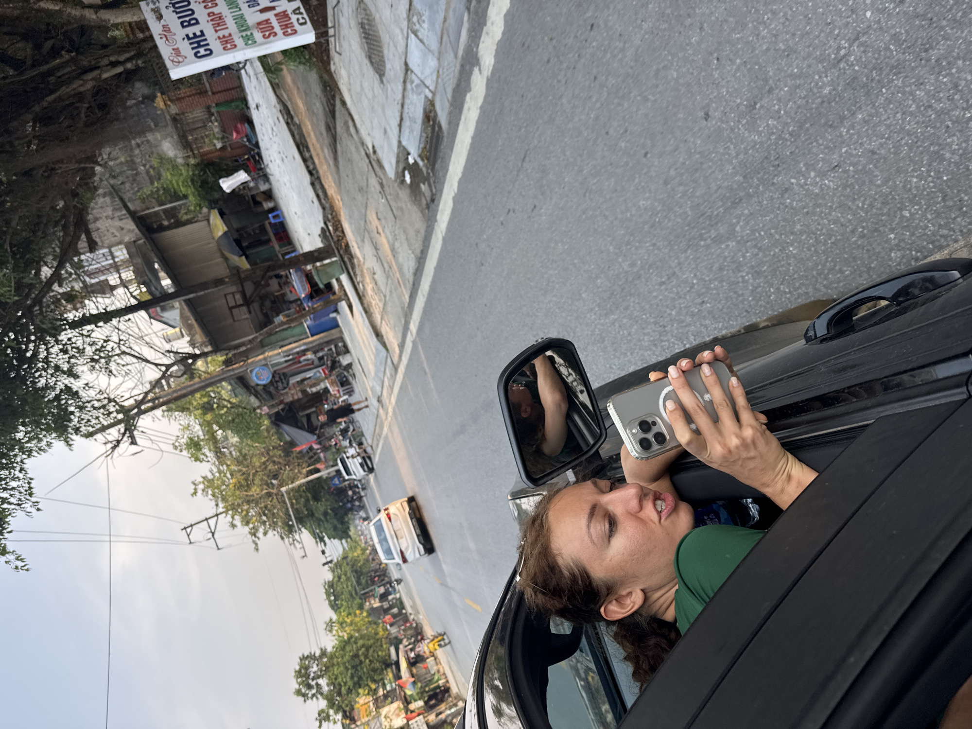 Woman films from car window on Vietnamese street