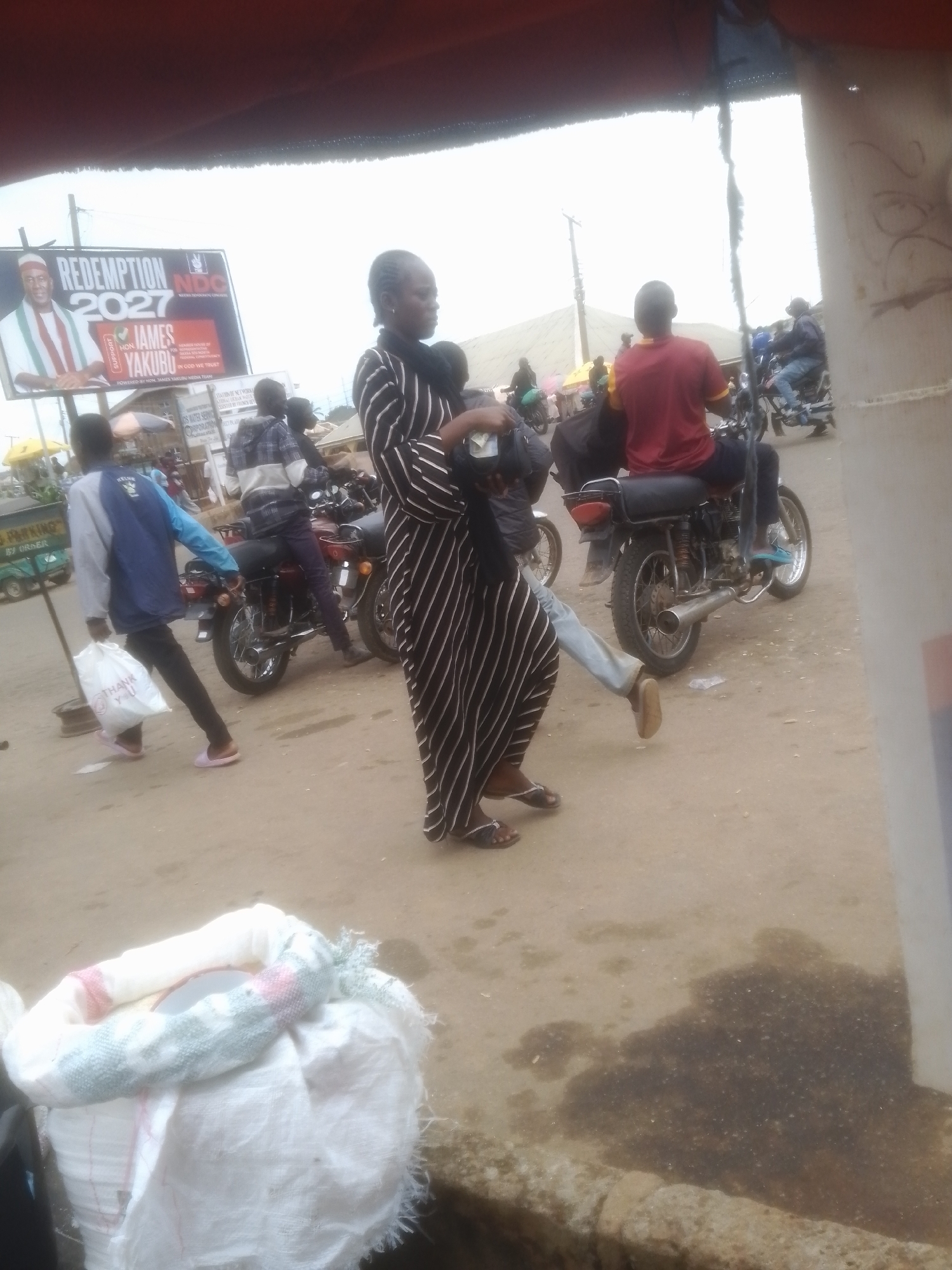 Everyday street activity in Gwong, Nigeria — vendors, motos, foot traffic