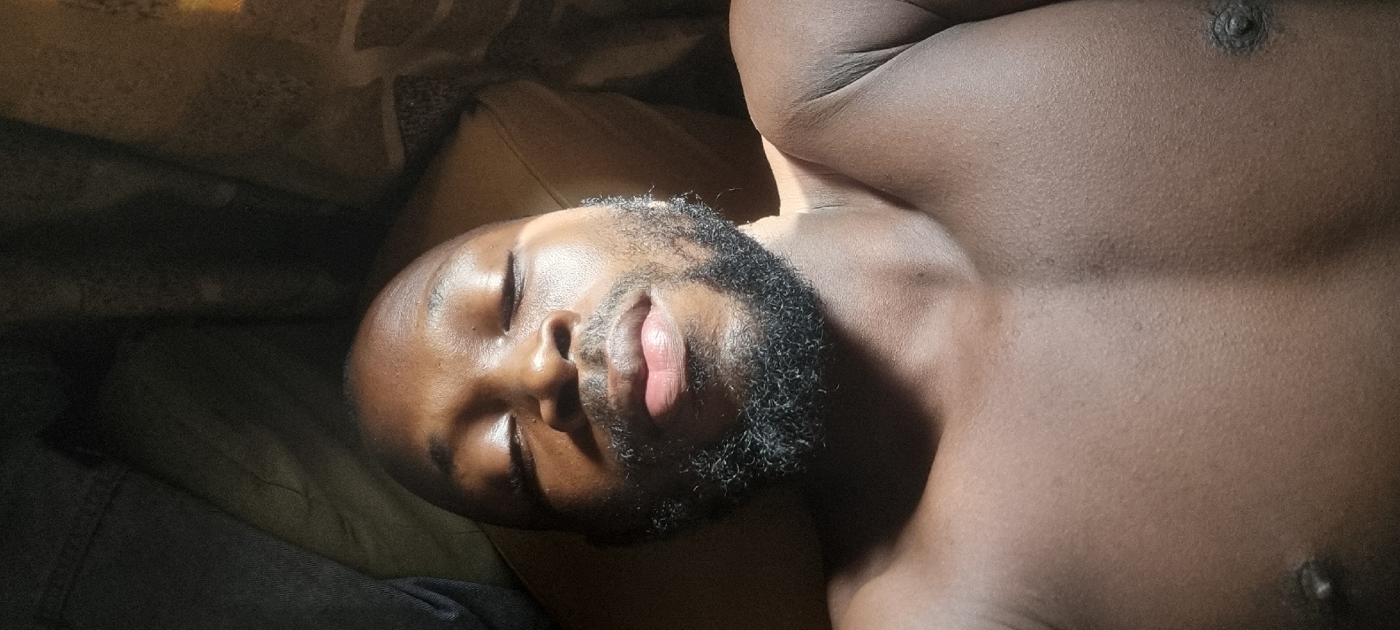 Man rests in sunlight on bed or couch
