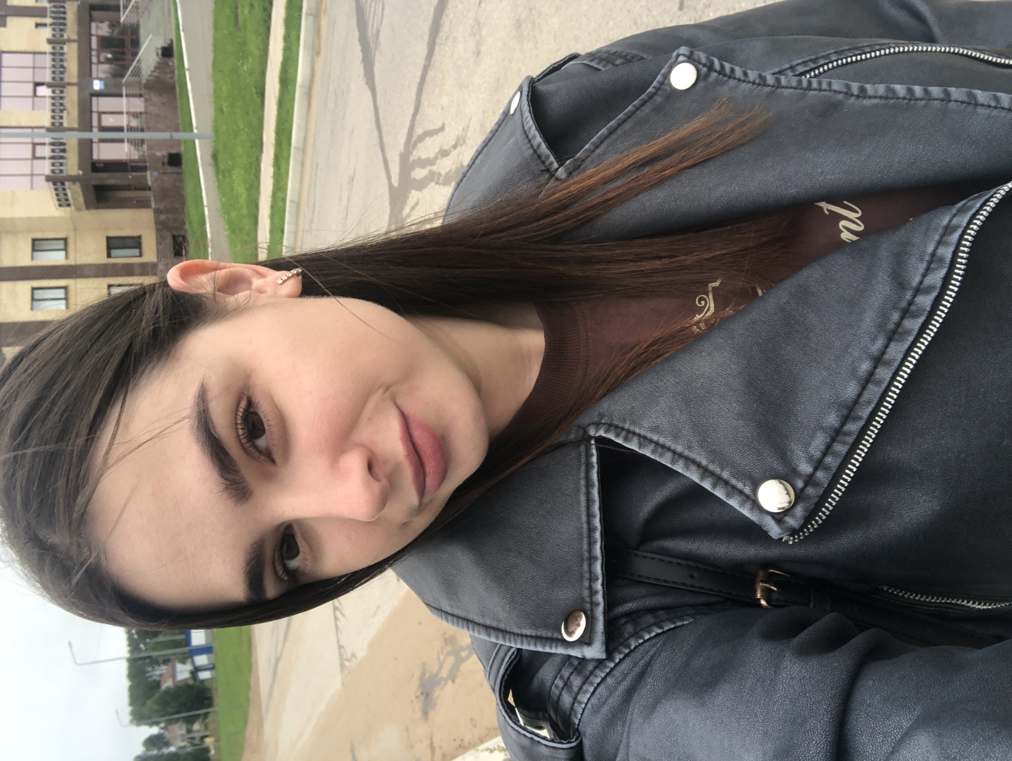 Casual outdoor selfies near a modern building in Noviy, Russia