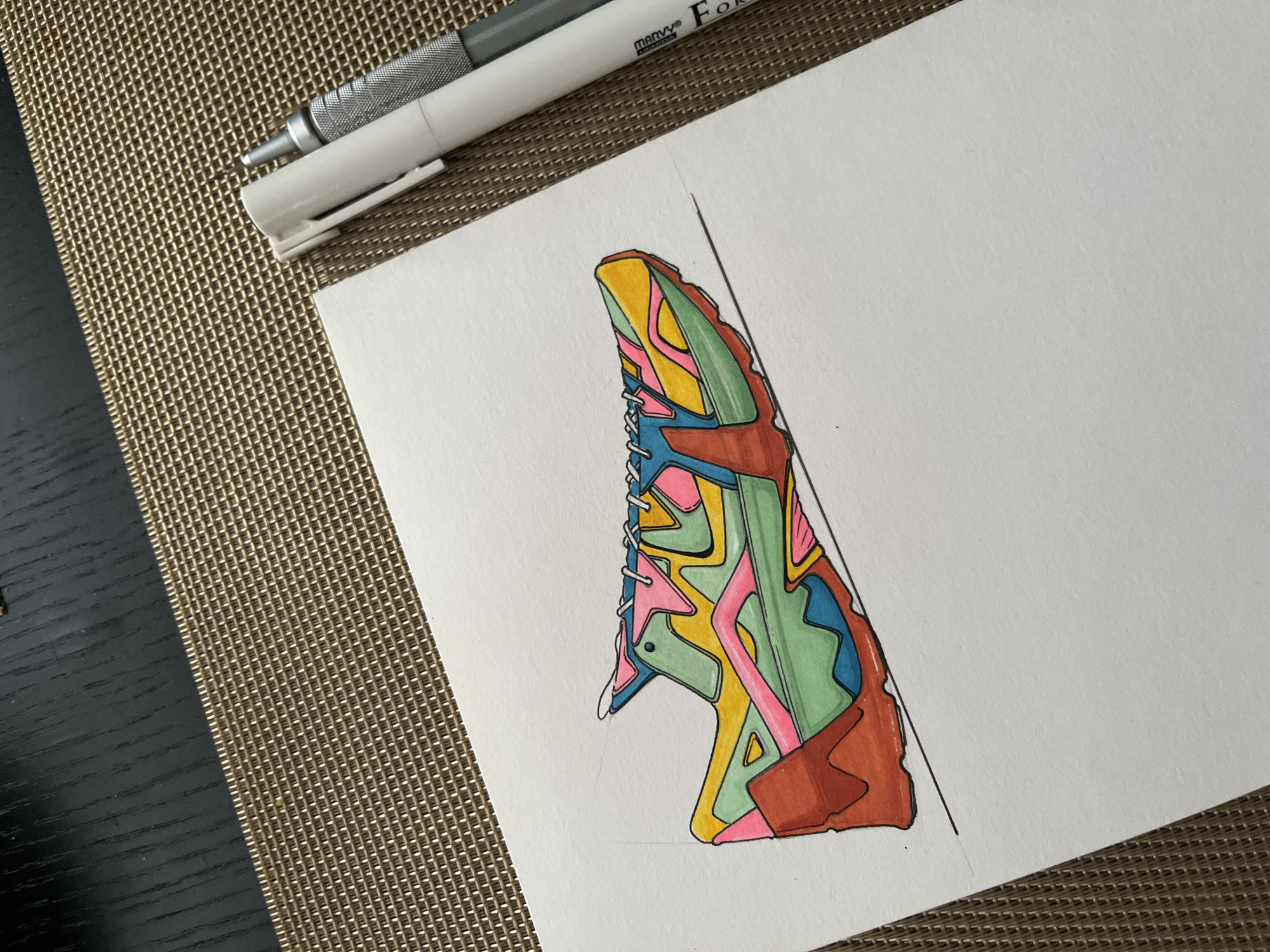 Colorful sneaker drawing captured with pens on wooden surface