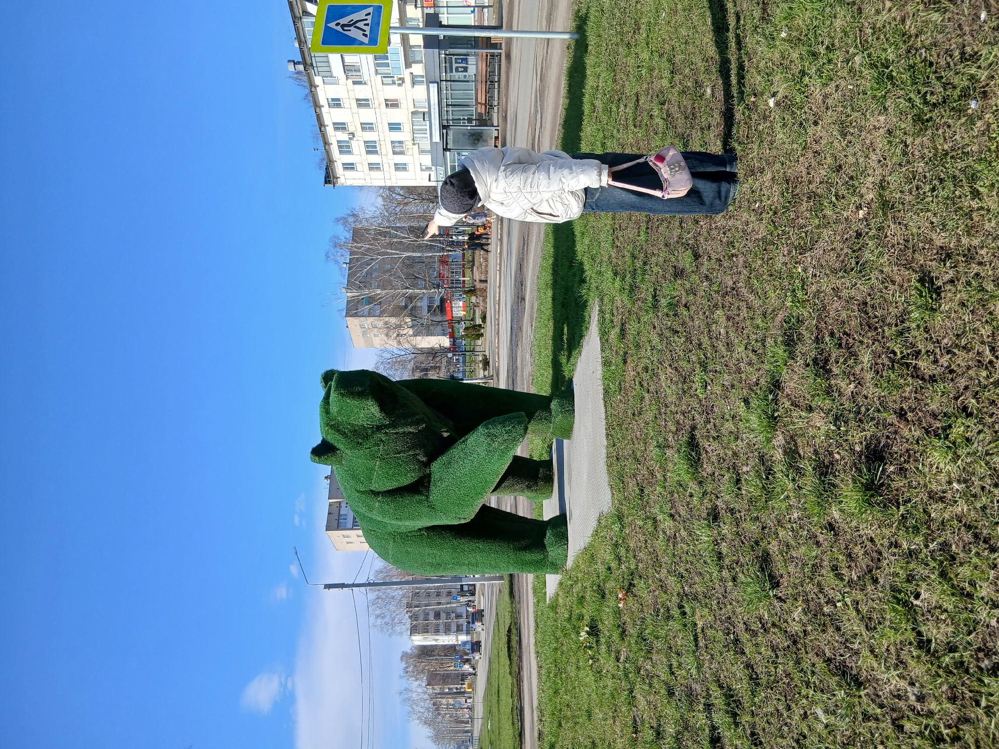 Urban park visitors enjoy spring morning activities, topiary sculptures