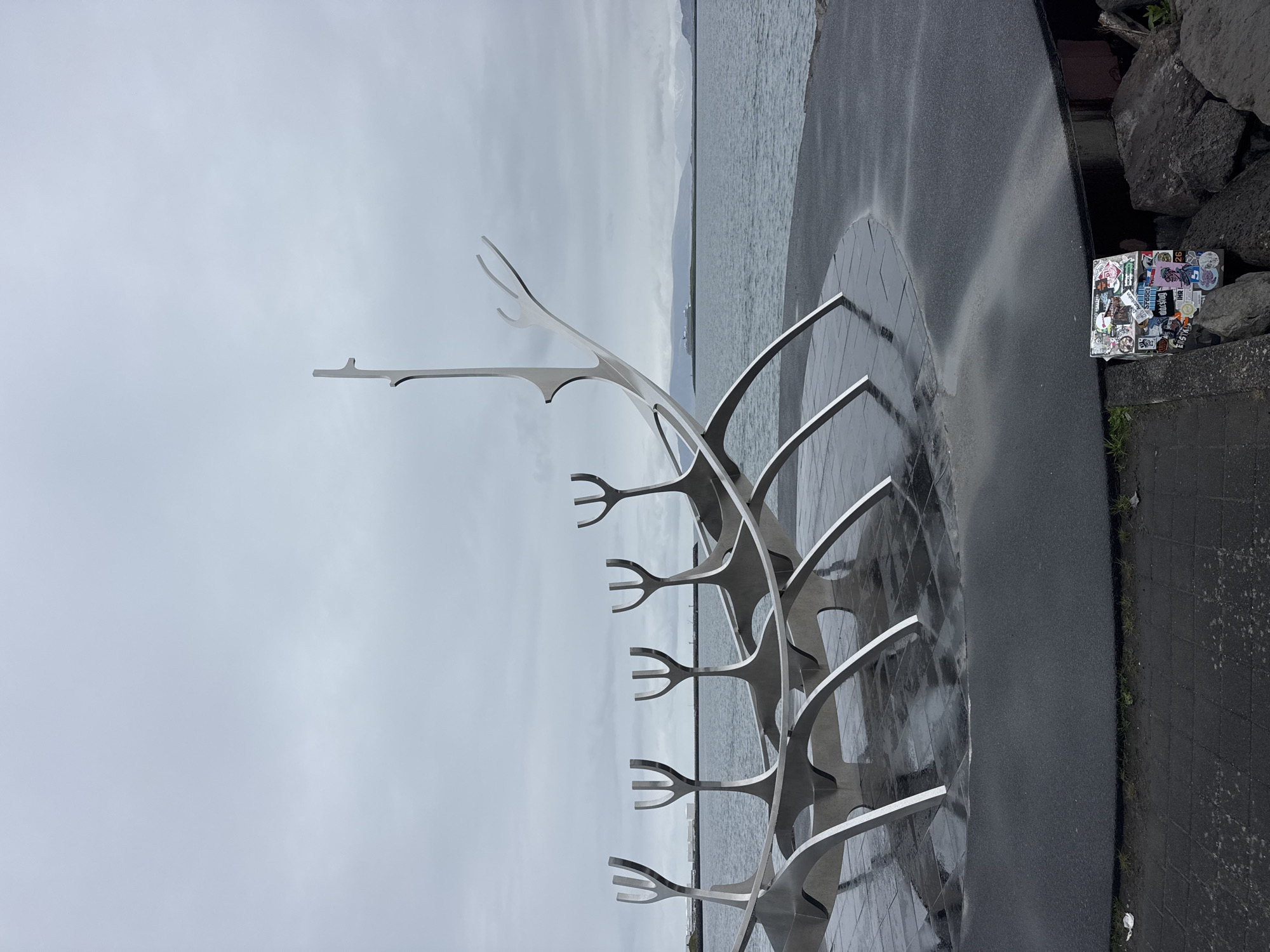 Tourists visit Sun Voyager sculpture in Reykjavik under grey skies