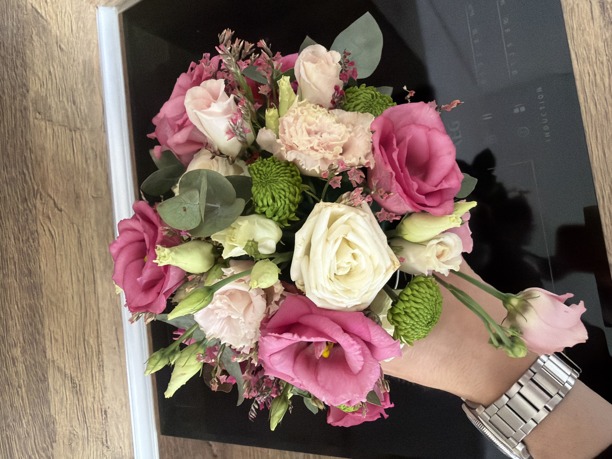 Person holds flower bouquet over kitchen cooktop in Sofia