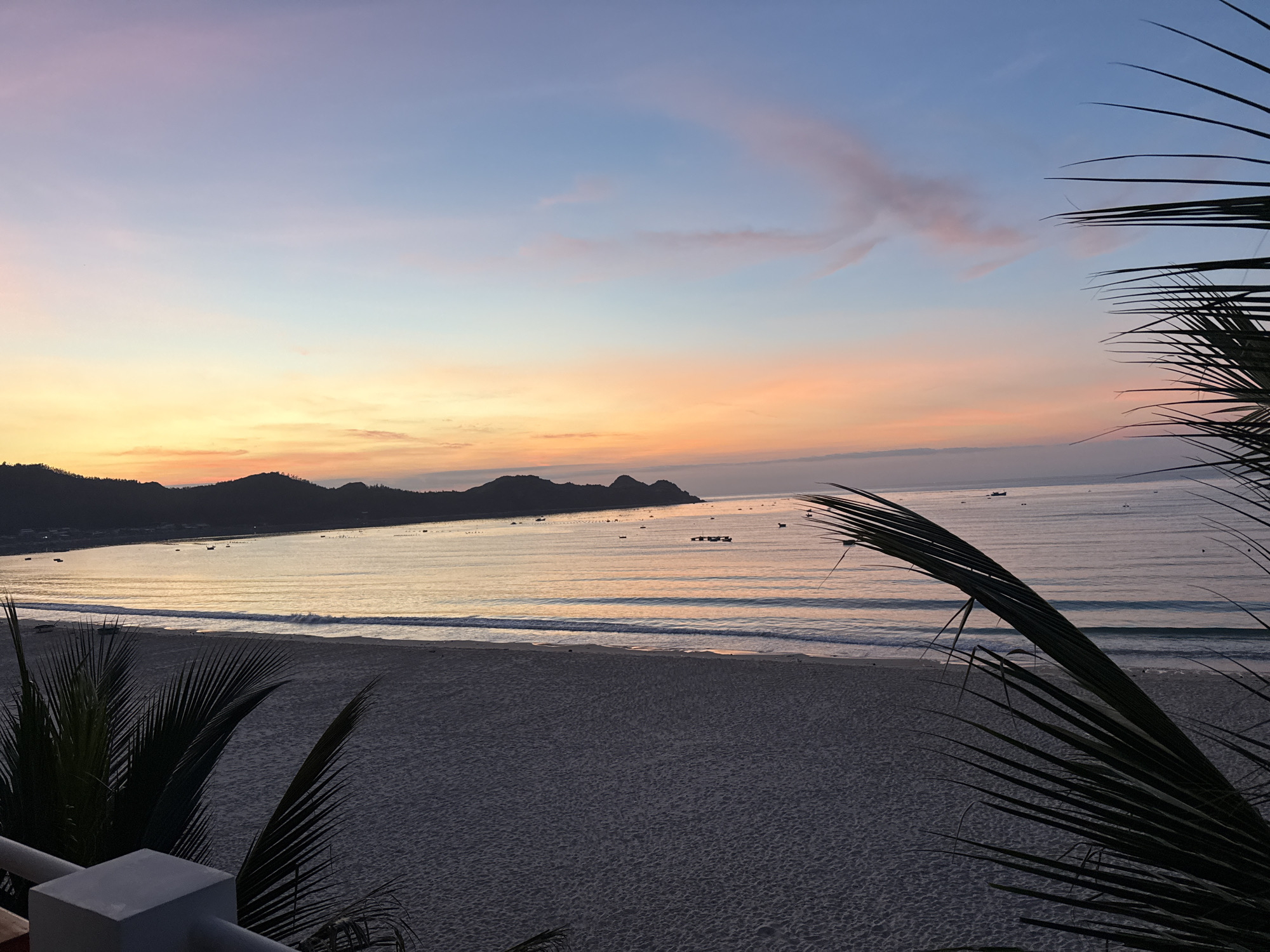 Golden hour at a coastal beach, mountains on the horizon