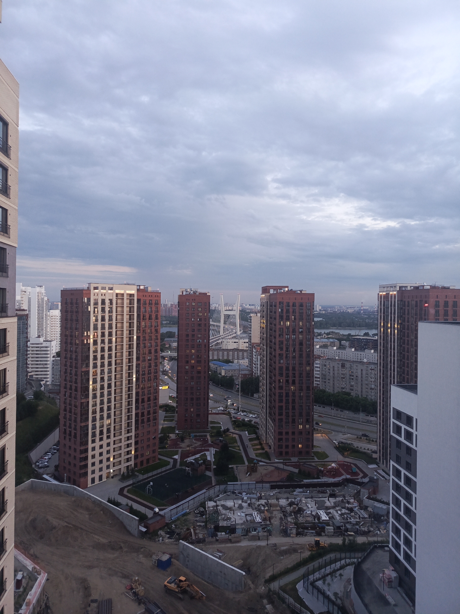 Novosibirsk at dusk: new towers, a park, and a cat on a cushion