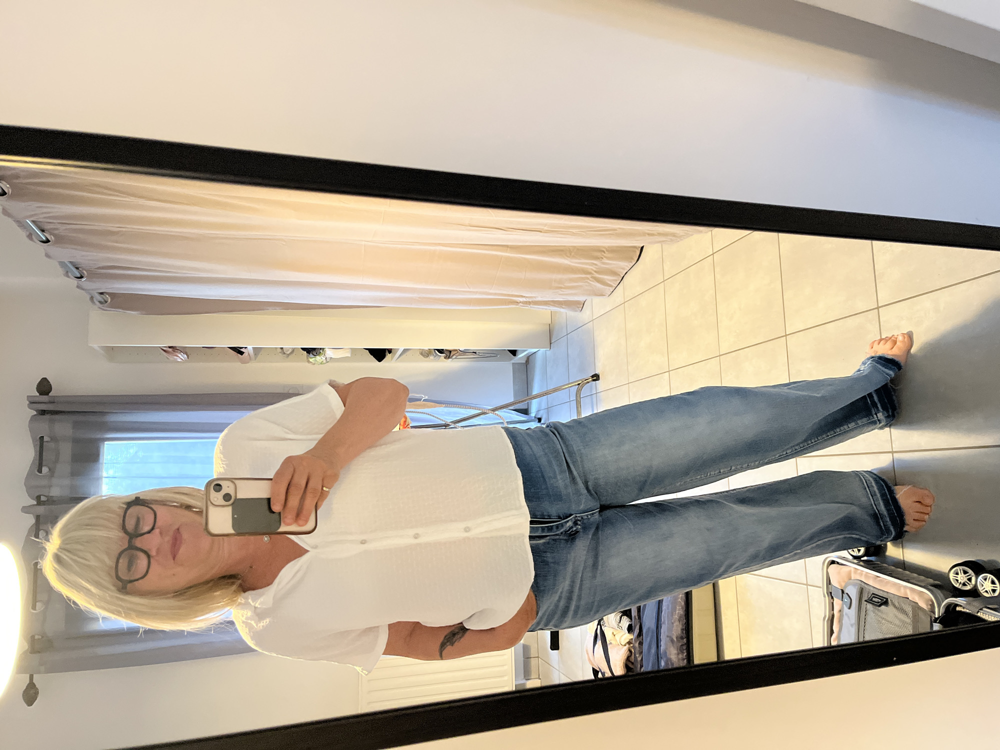 Woman takes morning mirror selfies in Chambœuf bedroom