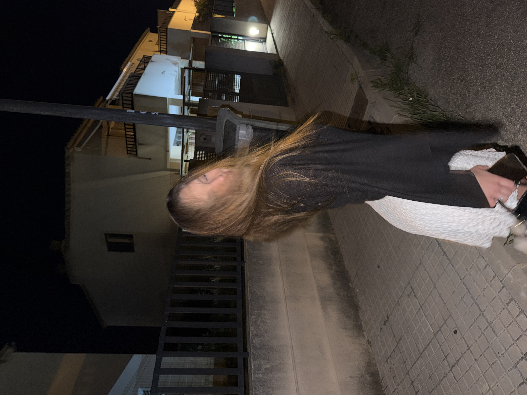 Woman in white dress photographed on Alcúdia streets at night