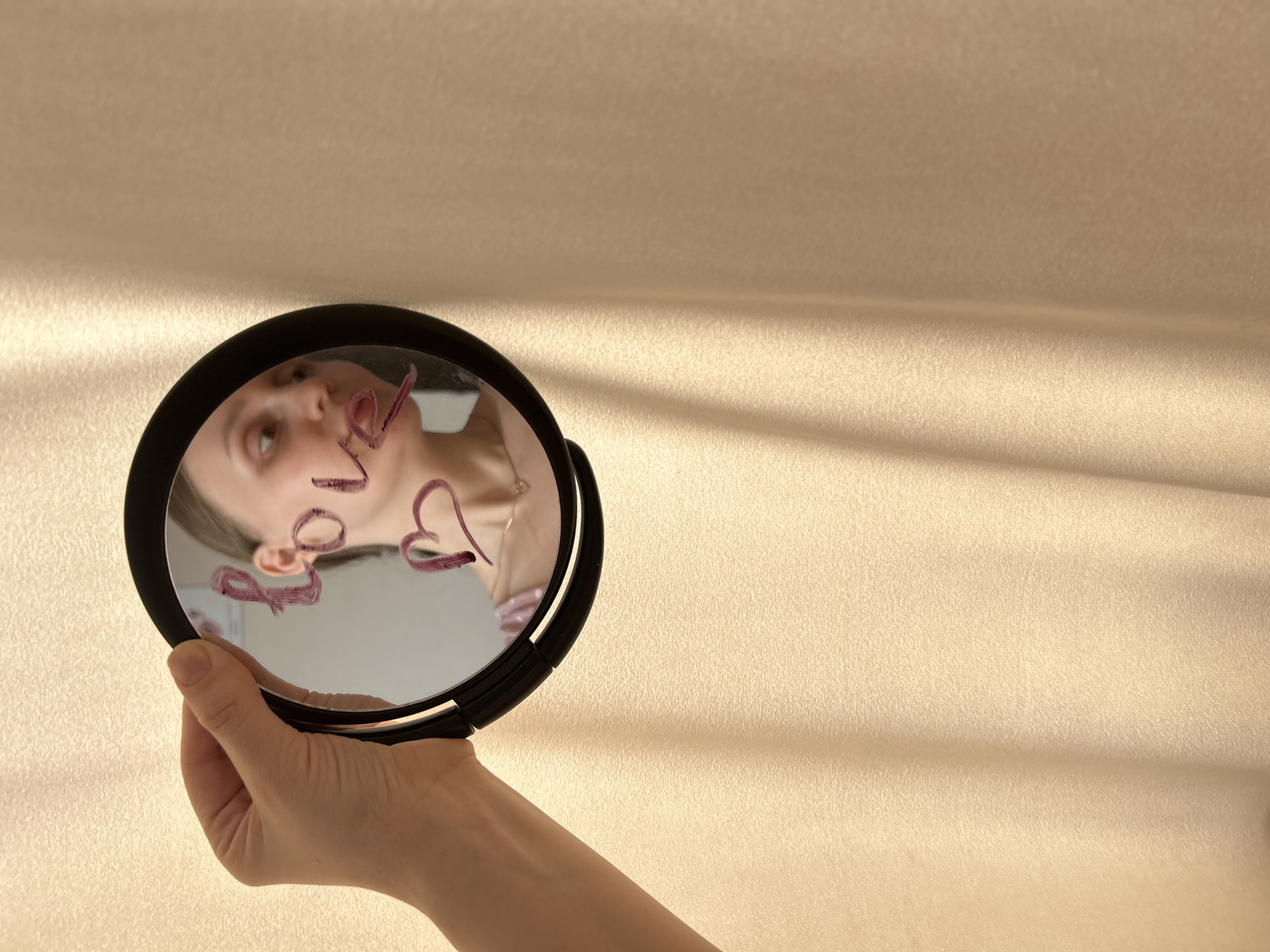 Woman holds mirror with 'love' written in lipstick, Ufa