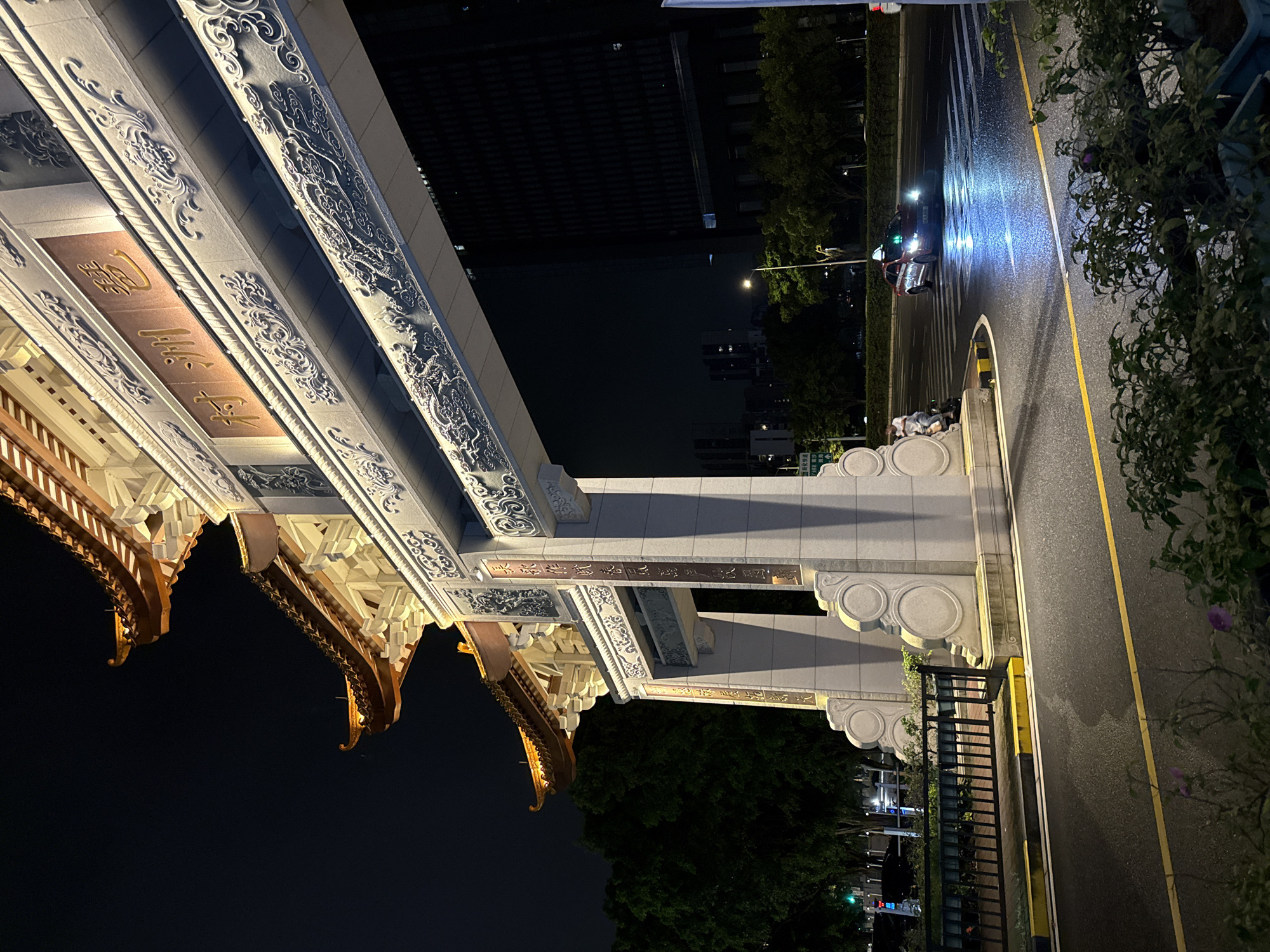 Rainy night in Haizhu: lit archway, wet streets, city in motion