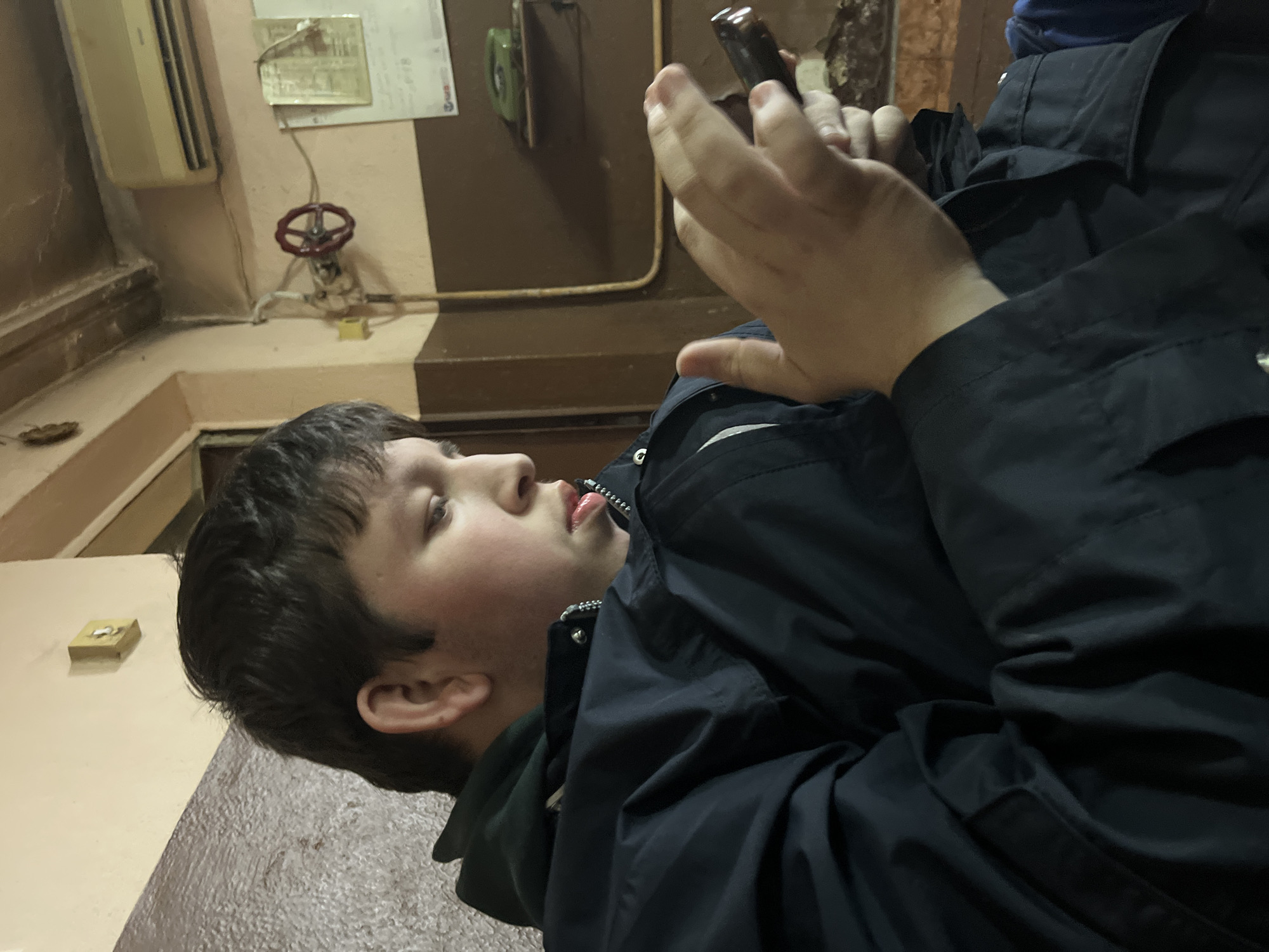 Youth uses handheld device in Sofia communal room
