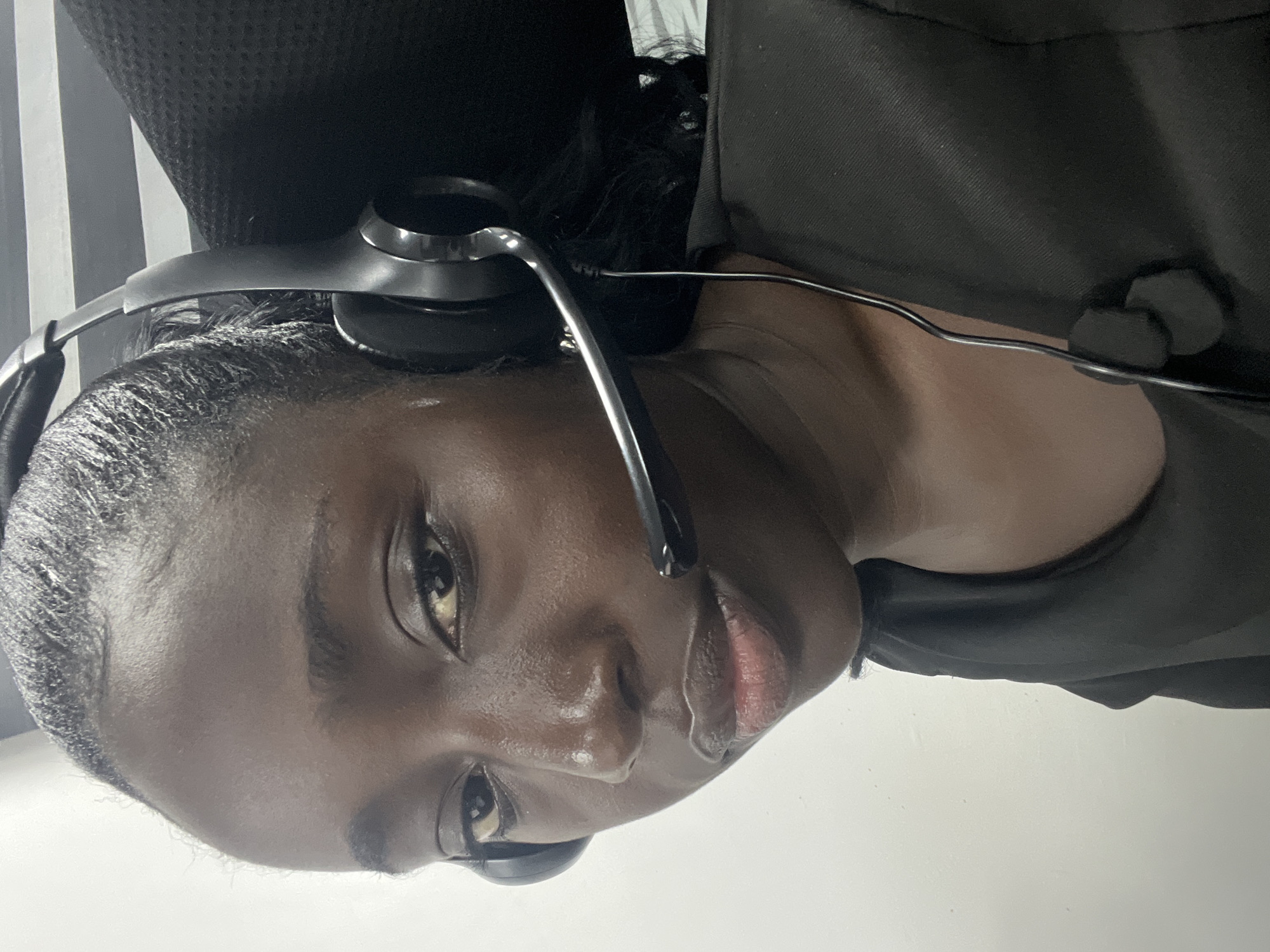 Woman photographed wearing headset in Karum office setting