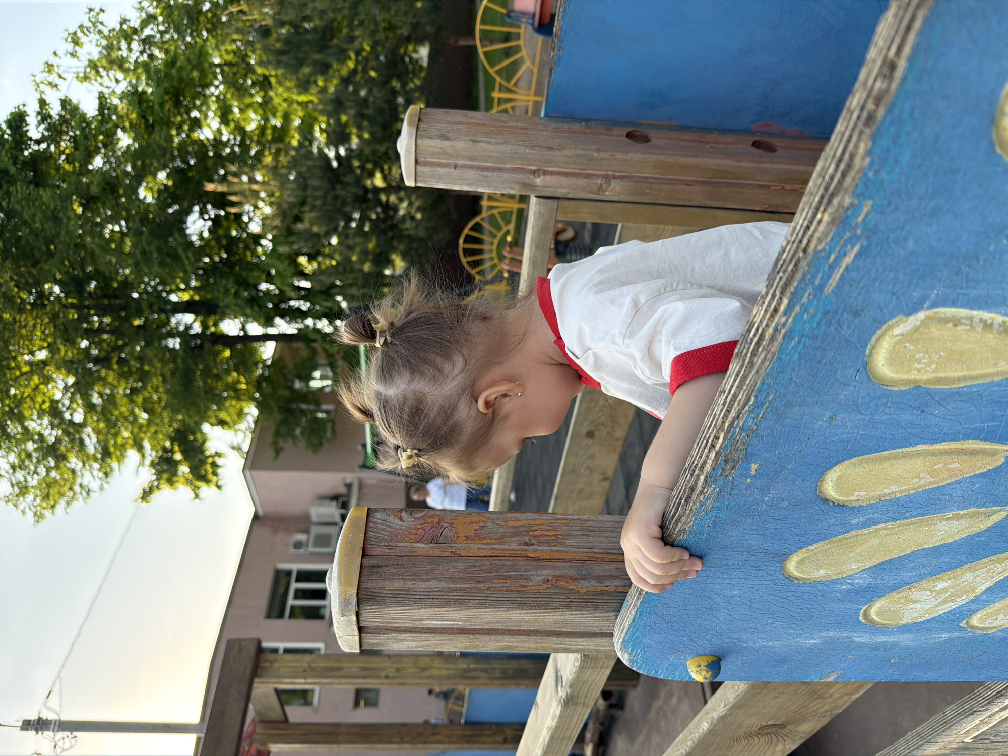 Toddler plays on playground equipment in Reshetnikovo, Russia