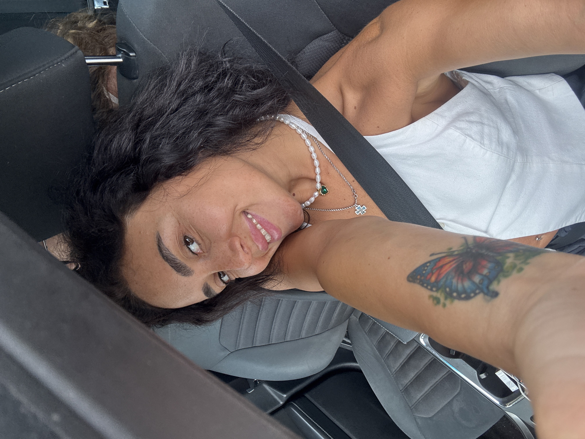 Quick in-car selfies in Tbilisi, pearl necklace and butterfly tattoo
