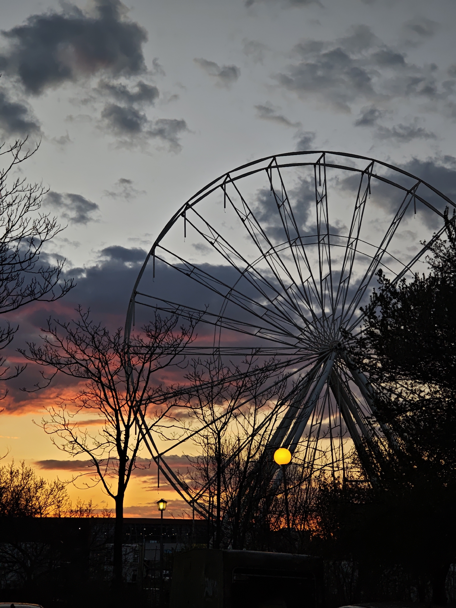 Dramatic sunset illuminates Plovdiv skyline with Ferris wheel silhouette