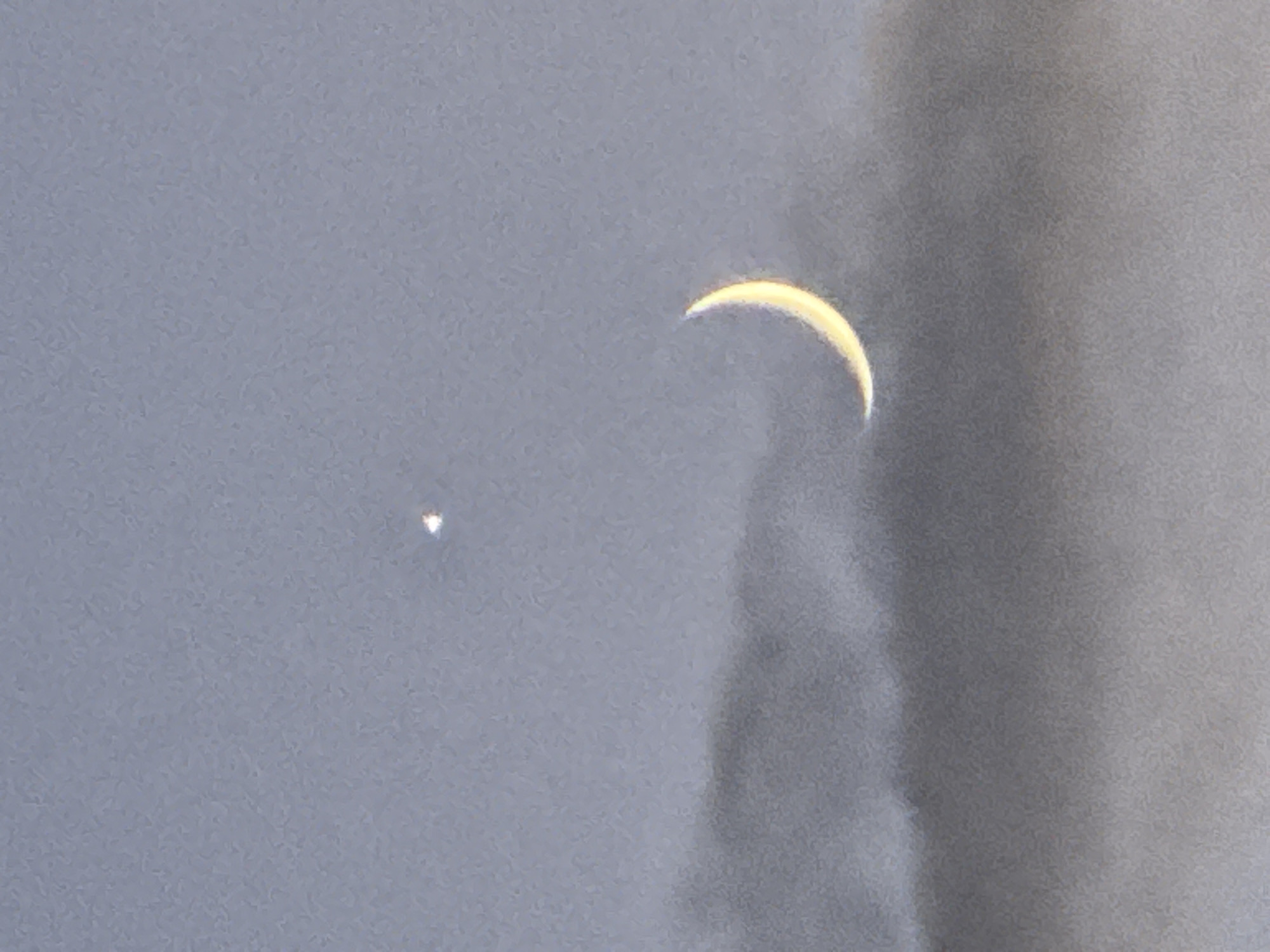 Crescent moon and bright planet at dusk over Bischheim