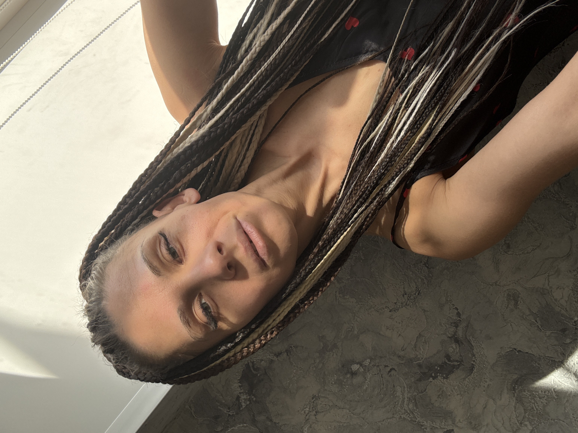 Woman with braided hair photographed indoors in dual poses